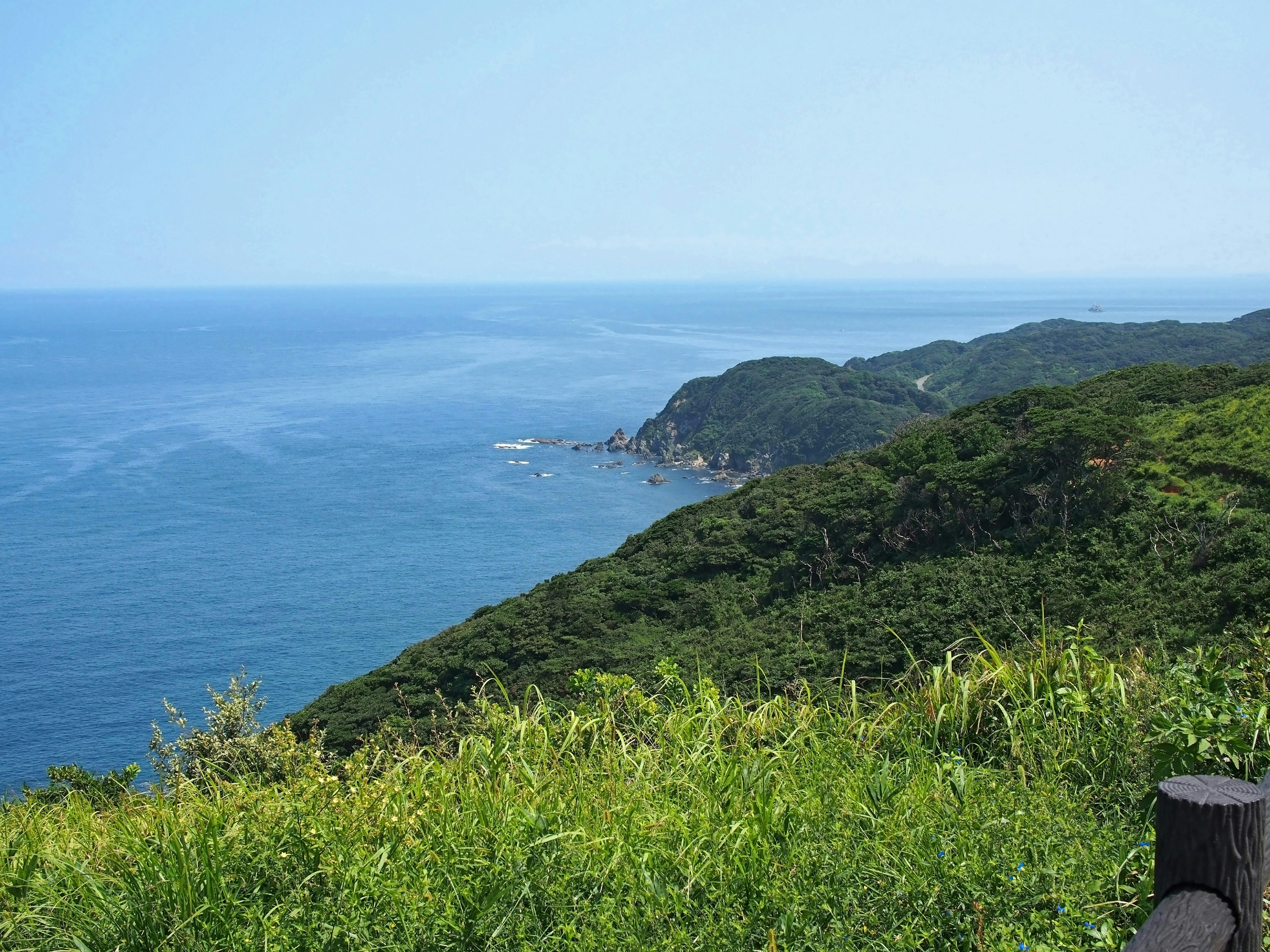 Scenic view of blue ocean and lush green hills