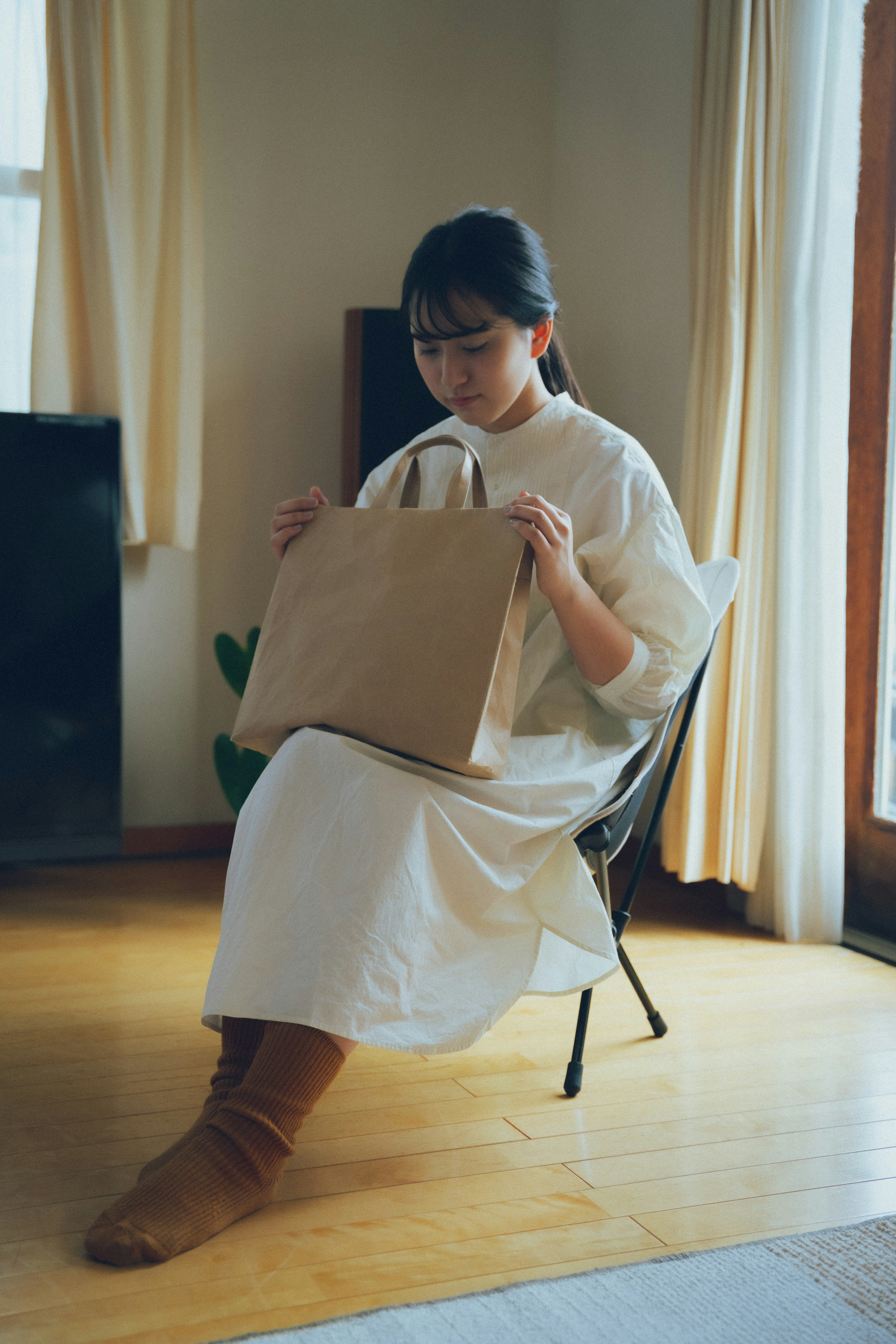 Une femme assise sur une chaise tenant un sac en papier brun