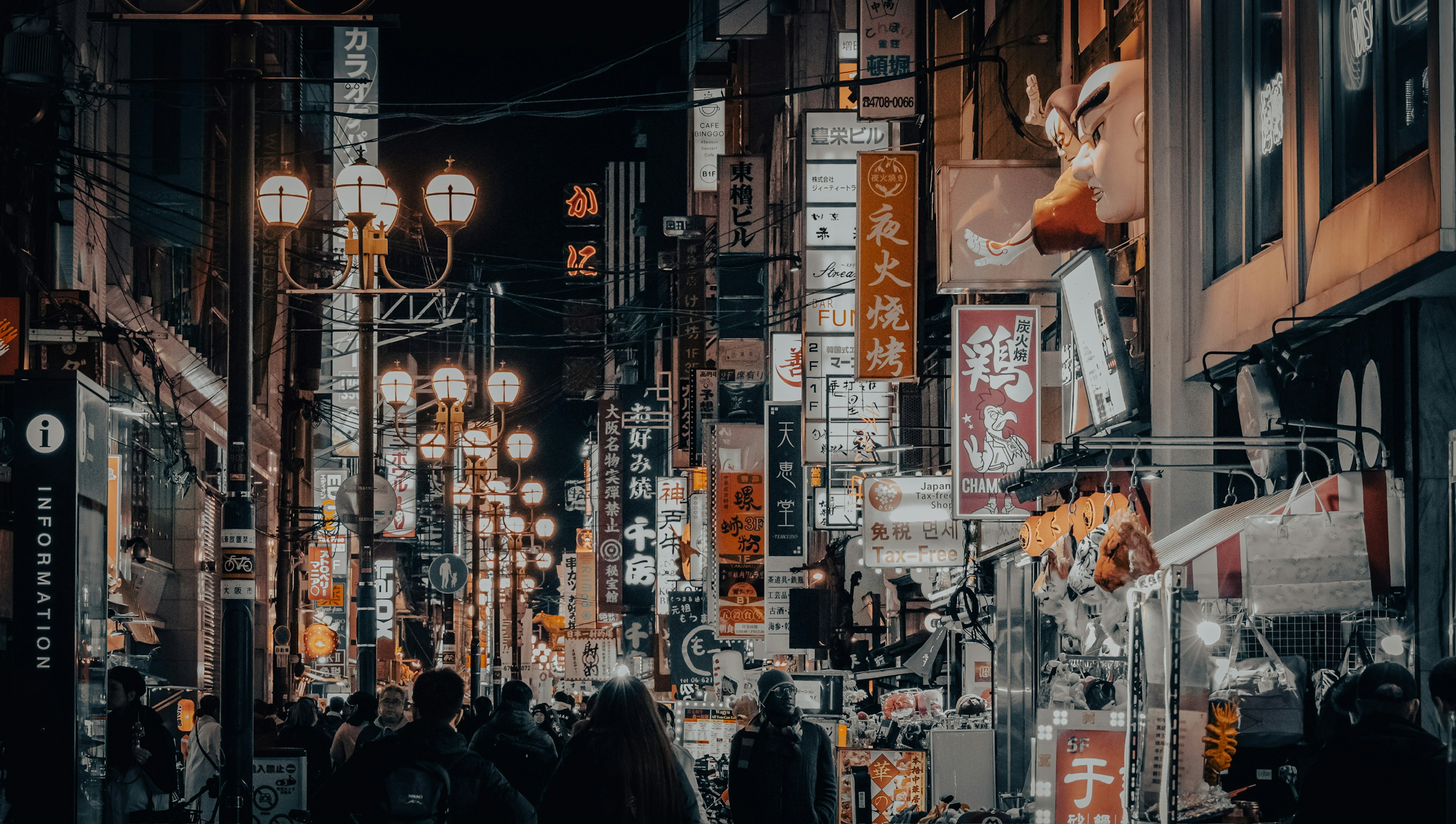 Night street scene with neon signs and people walking