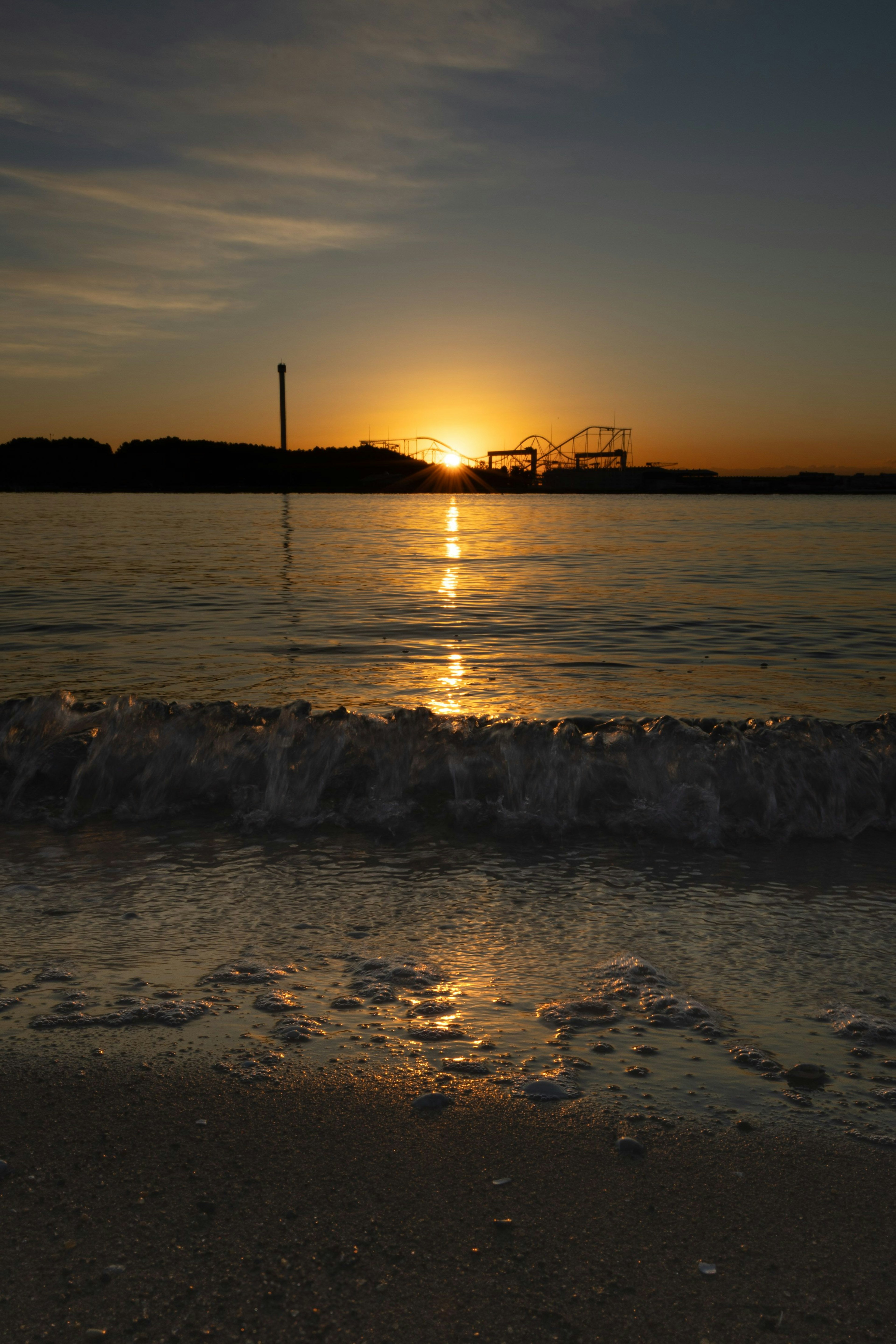 海岸での夕日が水面に反射している風景