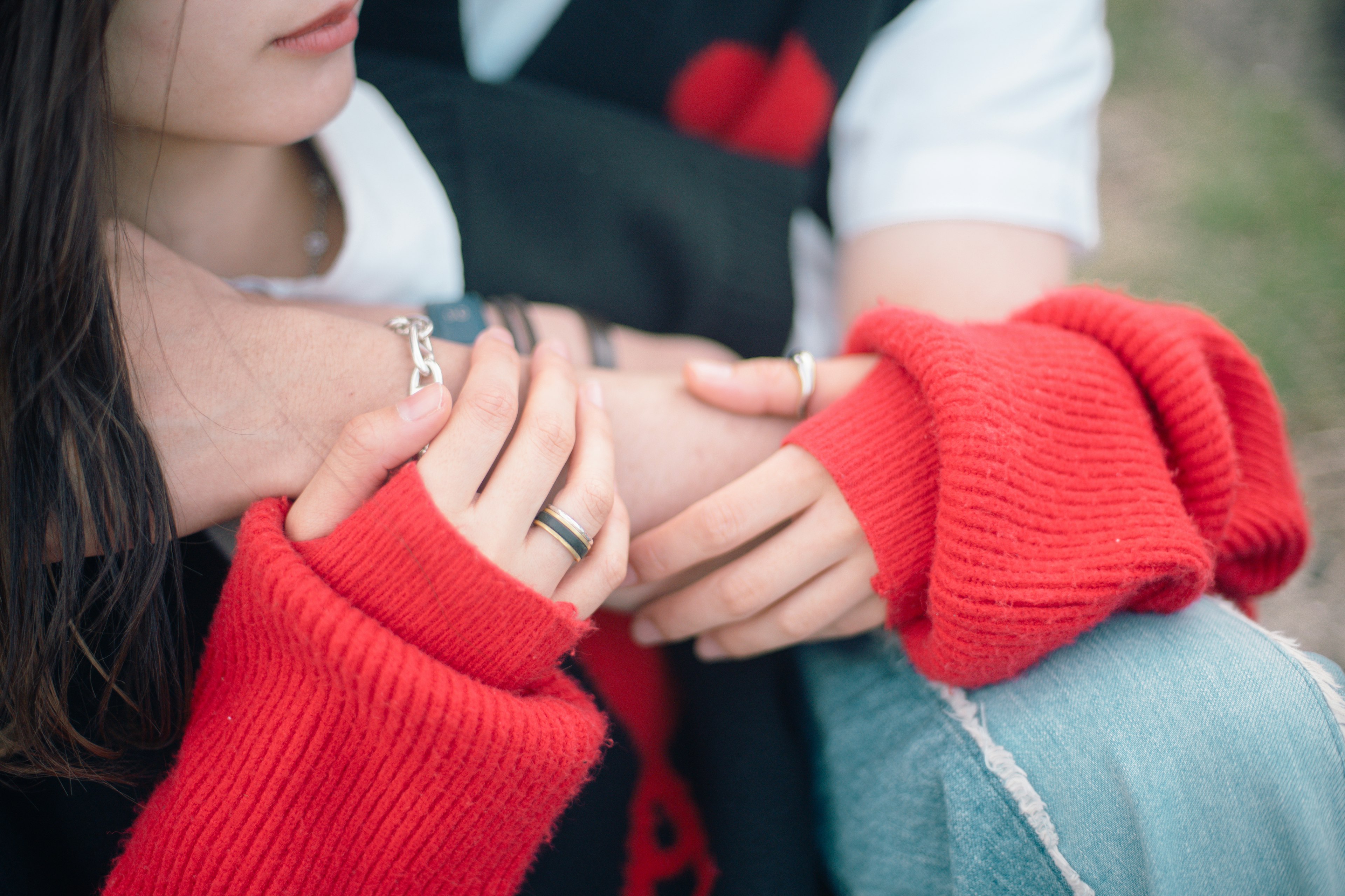 Couple's hands intertwined wearing a red sweater