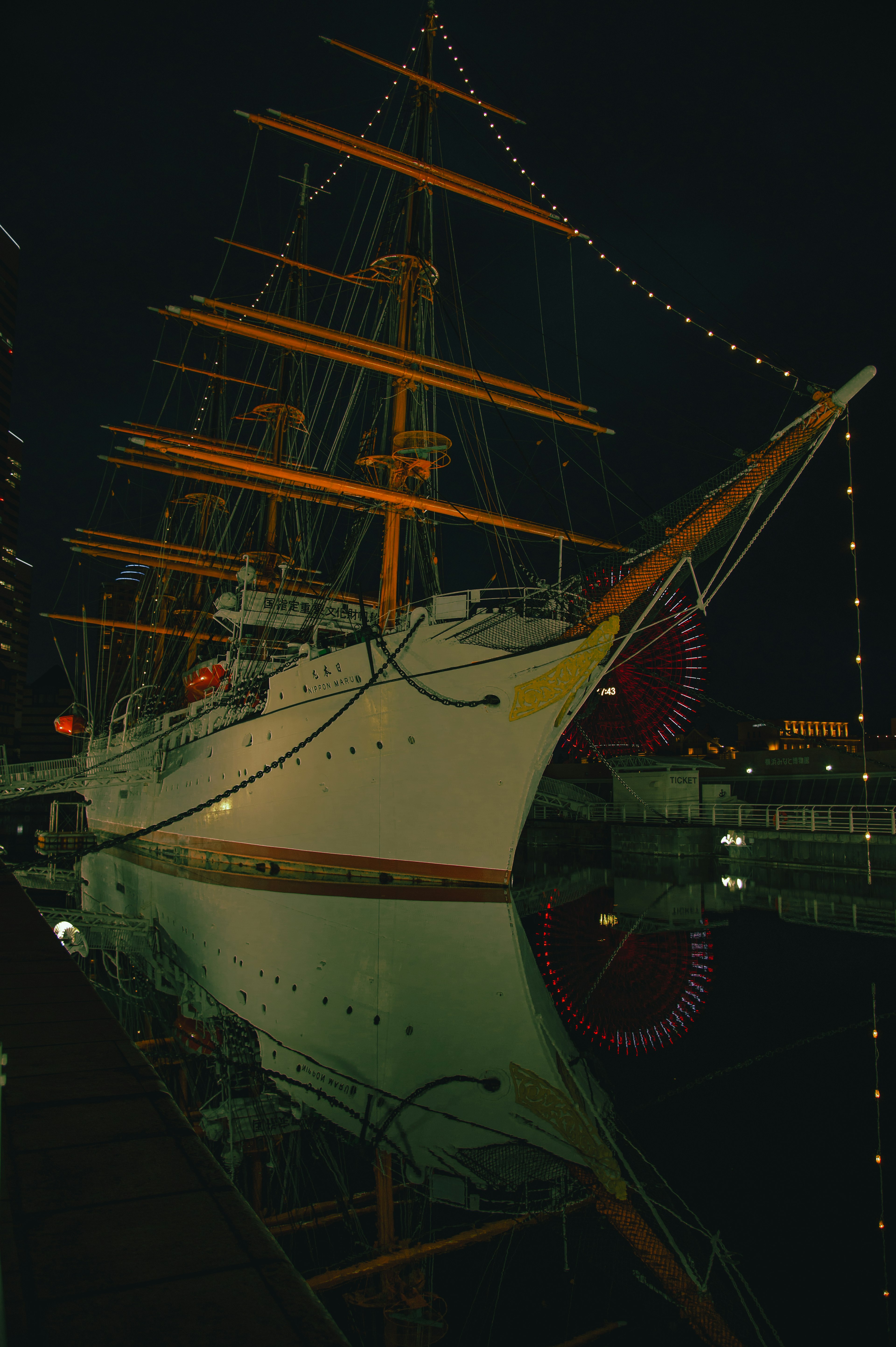 Hermoso barco de vela iluminado por la noche en un puerto