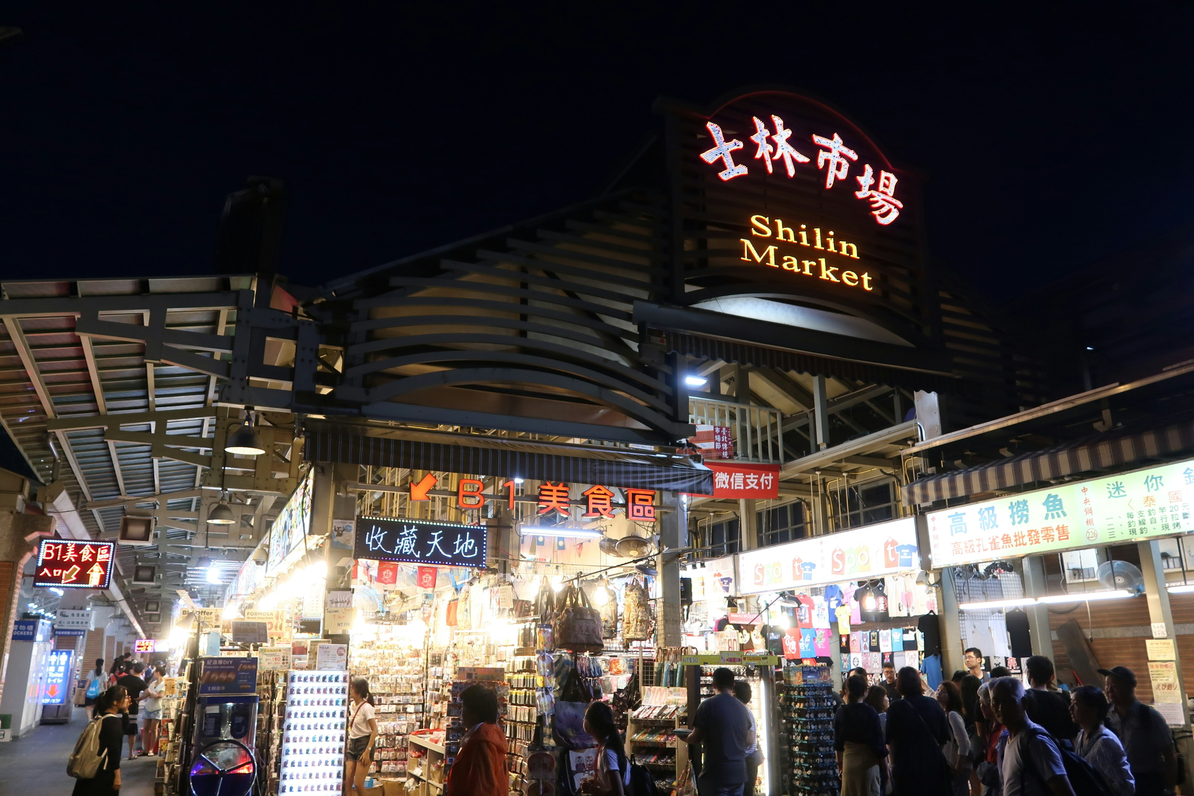 Bustling Shilin Market at night with vibrant lights