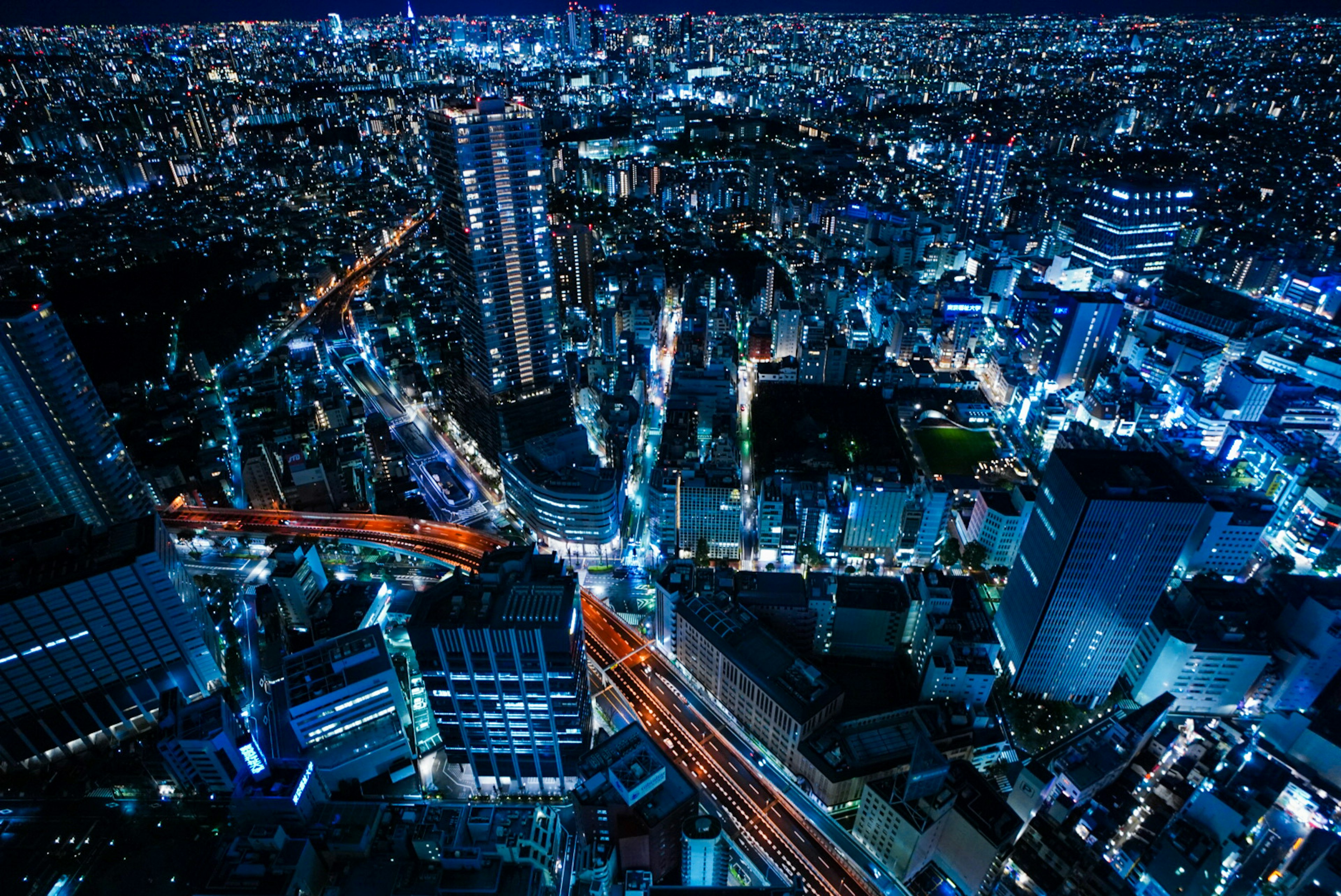 Paesaggio urbano notturno con grattacieli e strade illuminate di blu