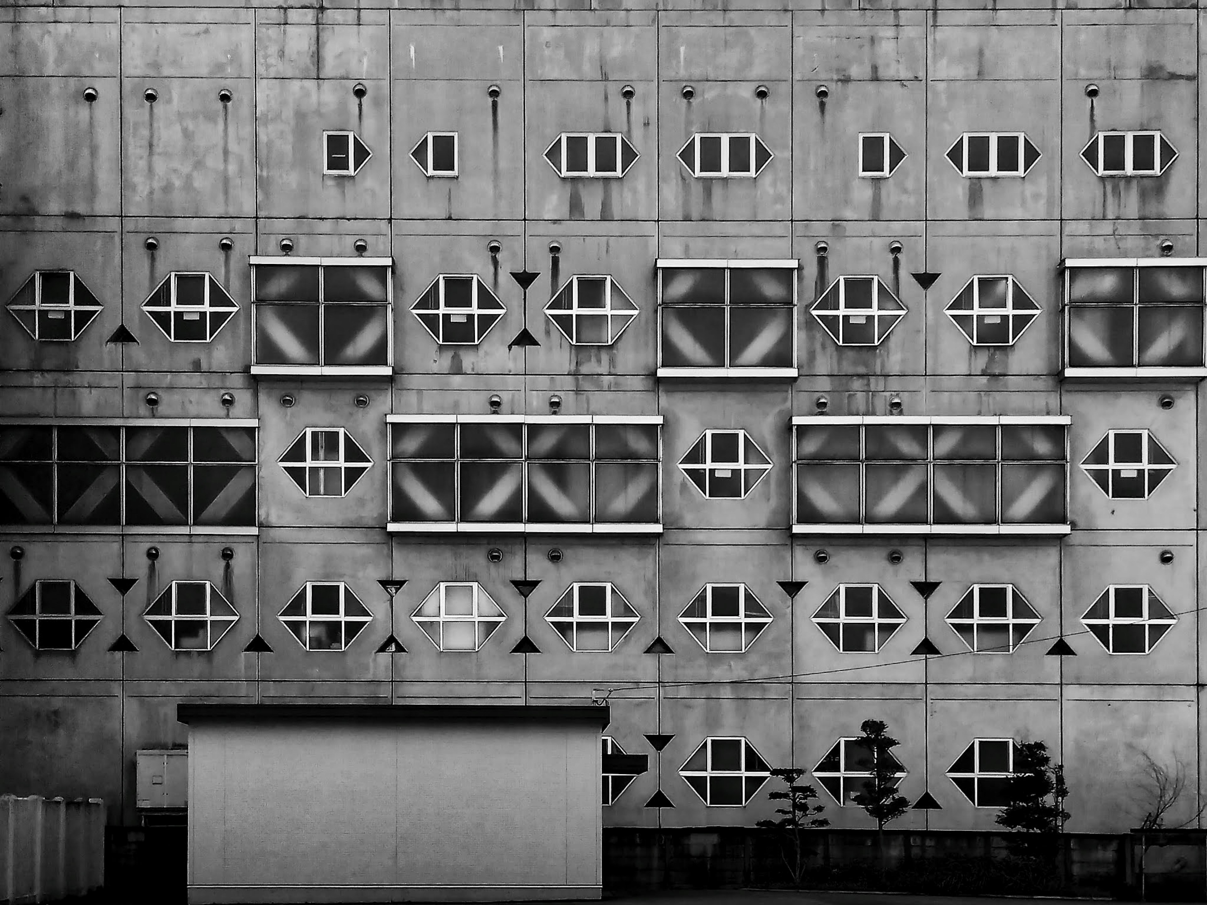 Patrones de ventanas geométricas en una pared de concreto