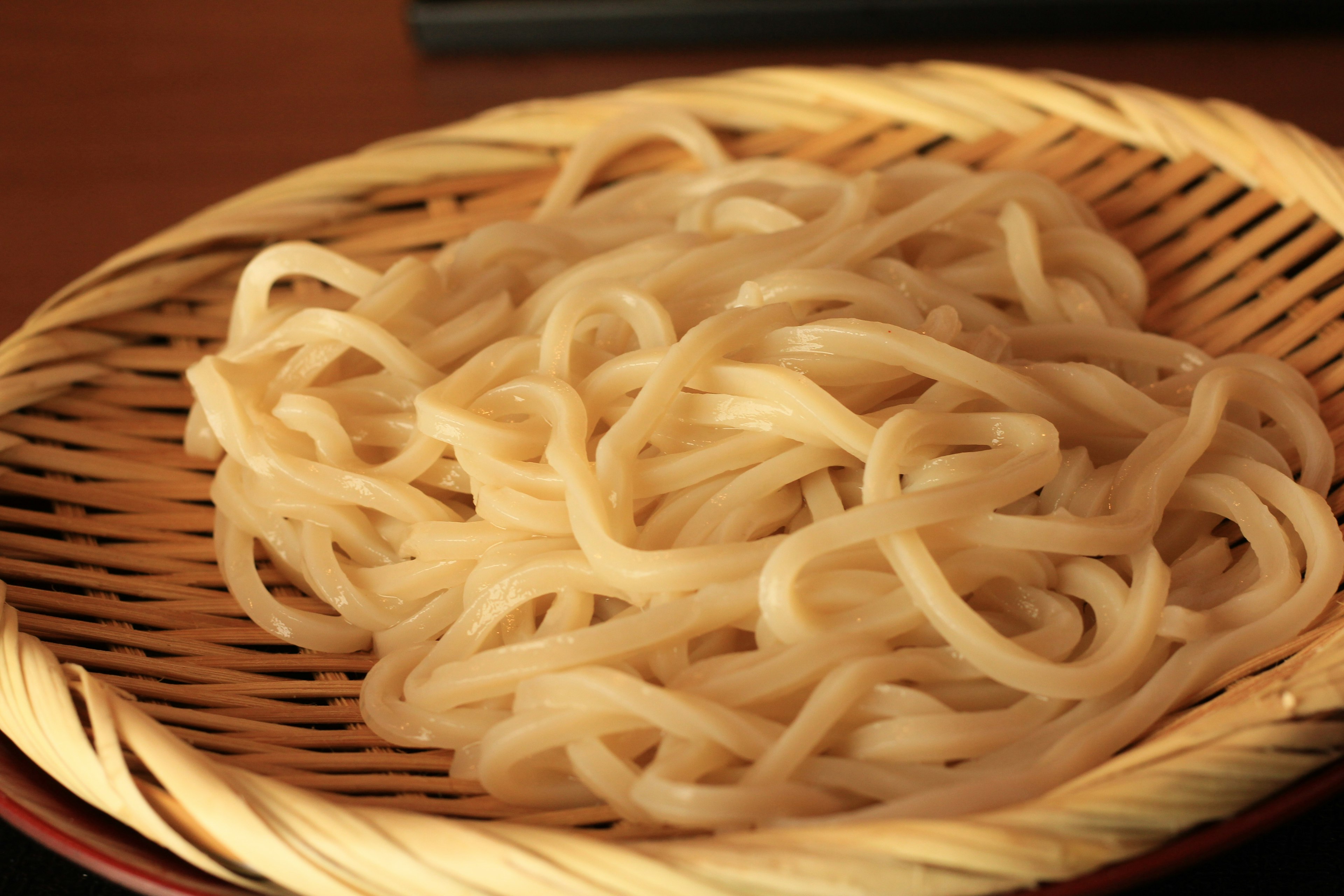 Fideos udon servidos en una cesta de bambú