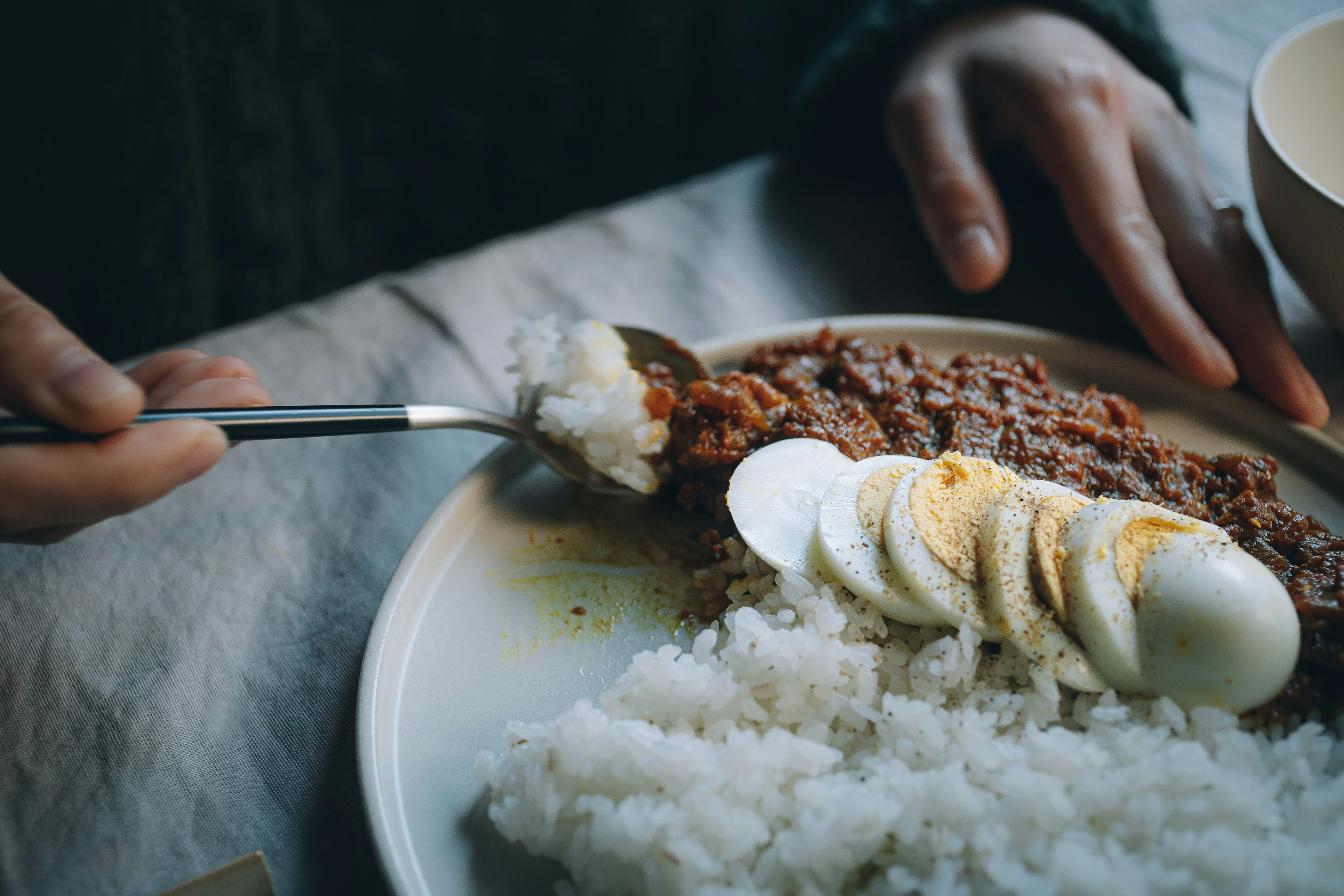 A plate featuring white rice and sliced boiled eggs