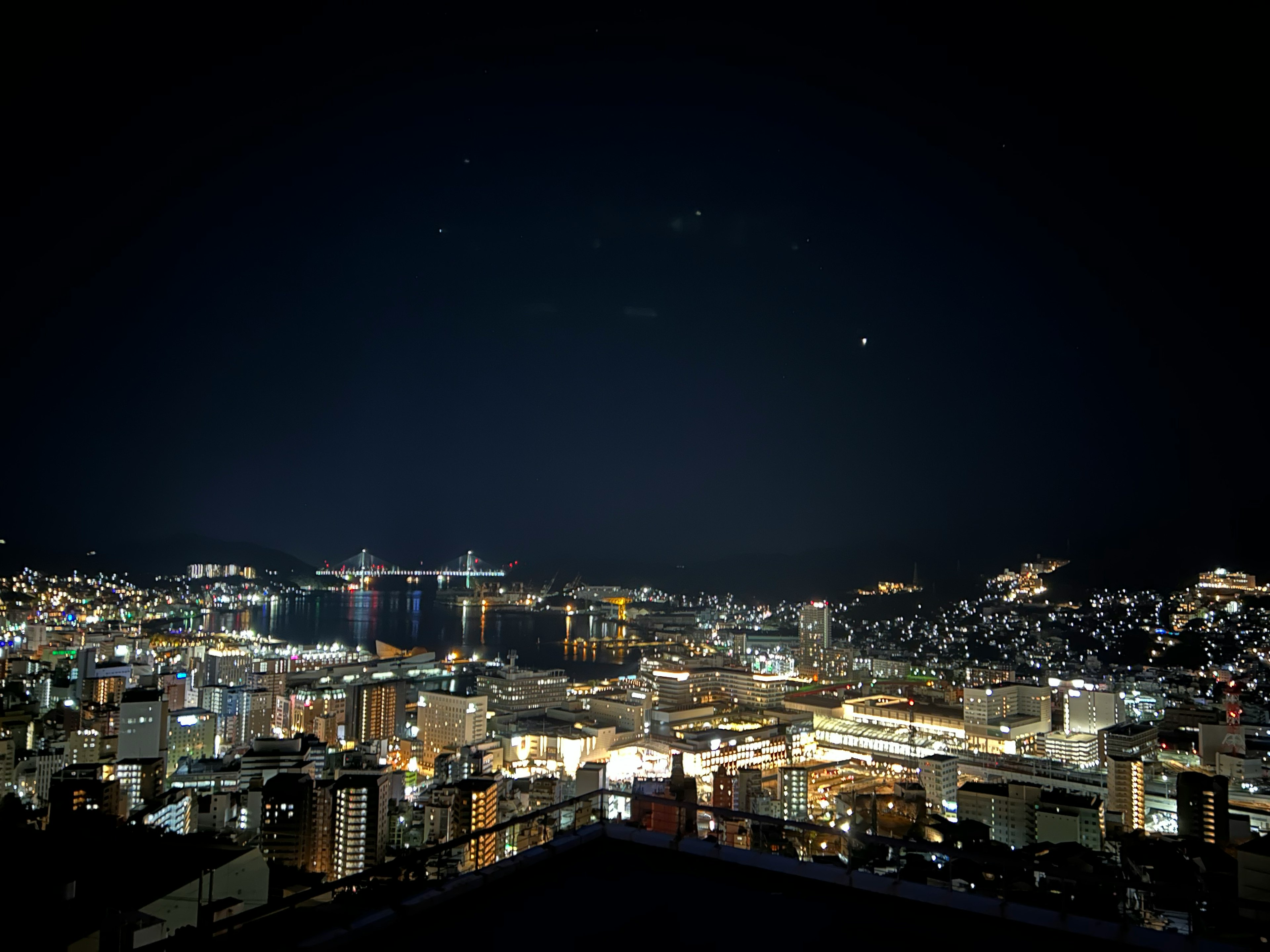 Vue panoramique d'une ville la nuit bâtiments illuminés et littoral