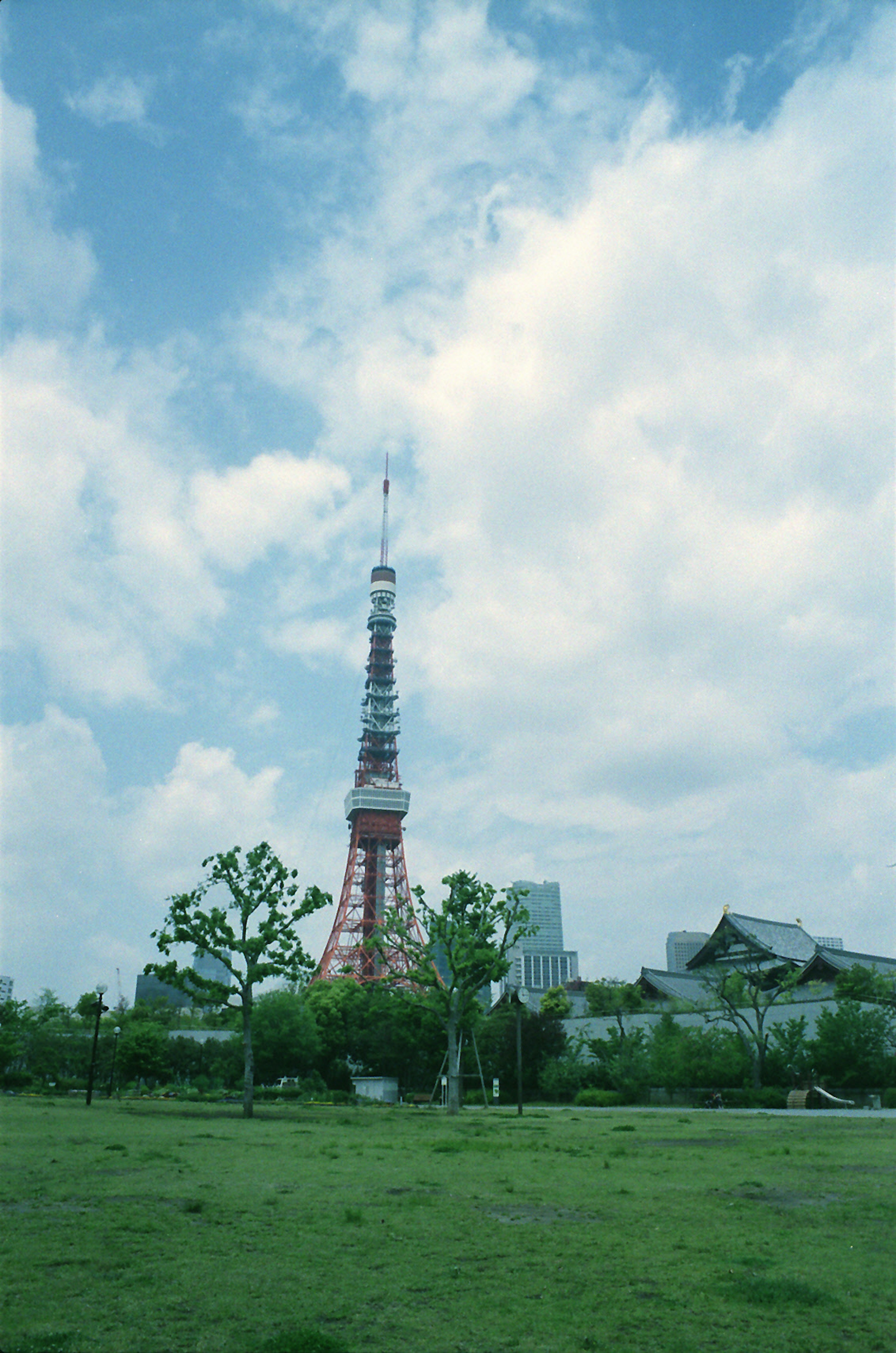 Torre di Tokyo contro un cielo blu con un parco verde in primo piano