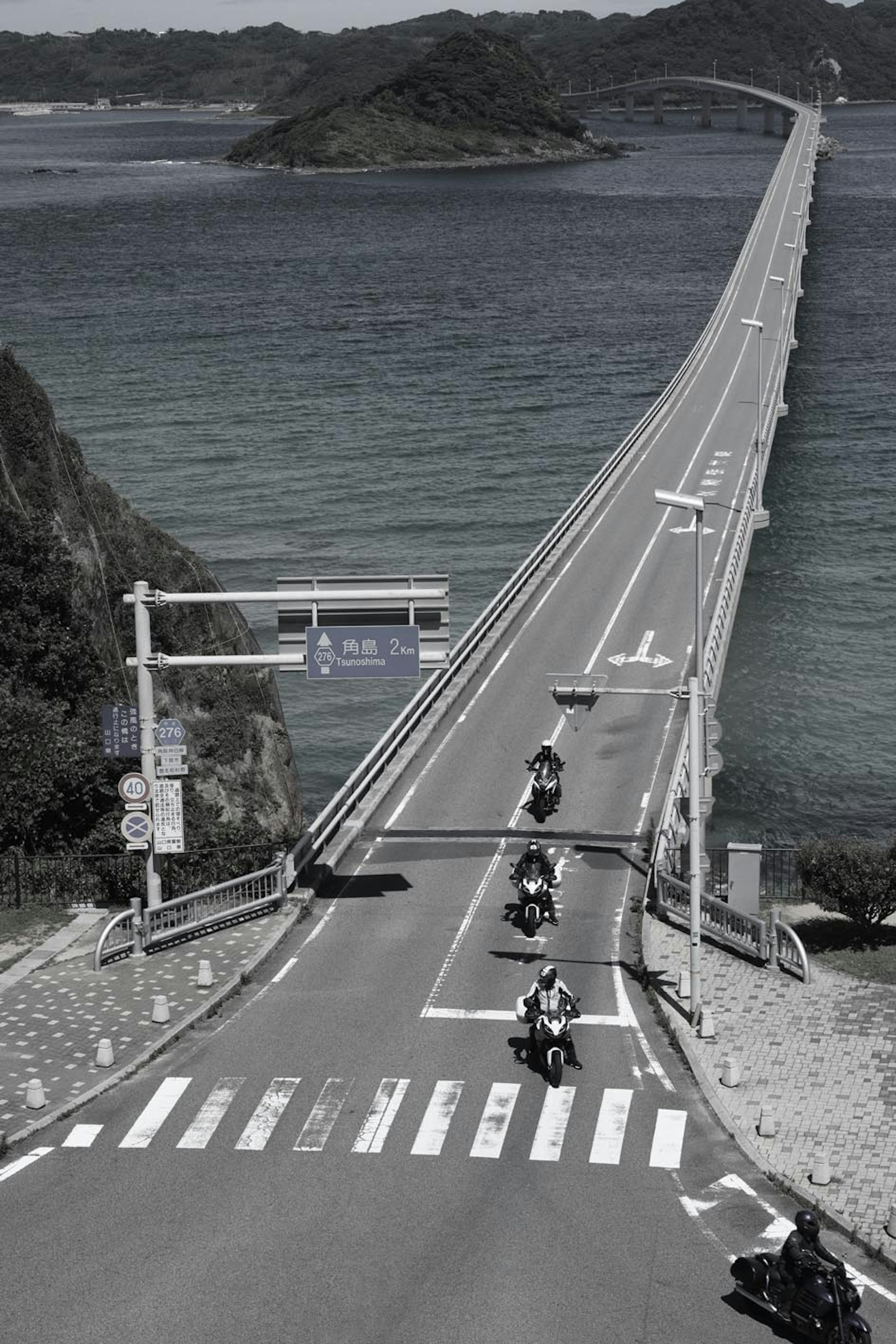 Eine Gruppe von Motorrädern auf einer langen Brücke über das Meer