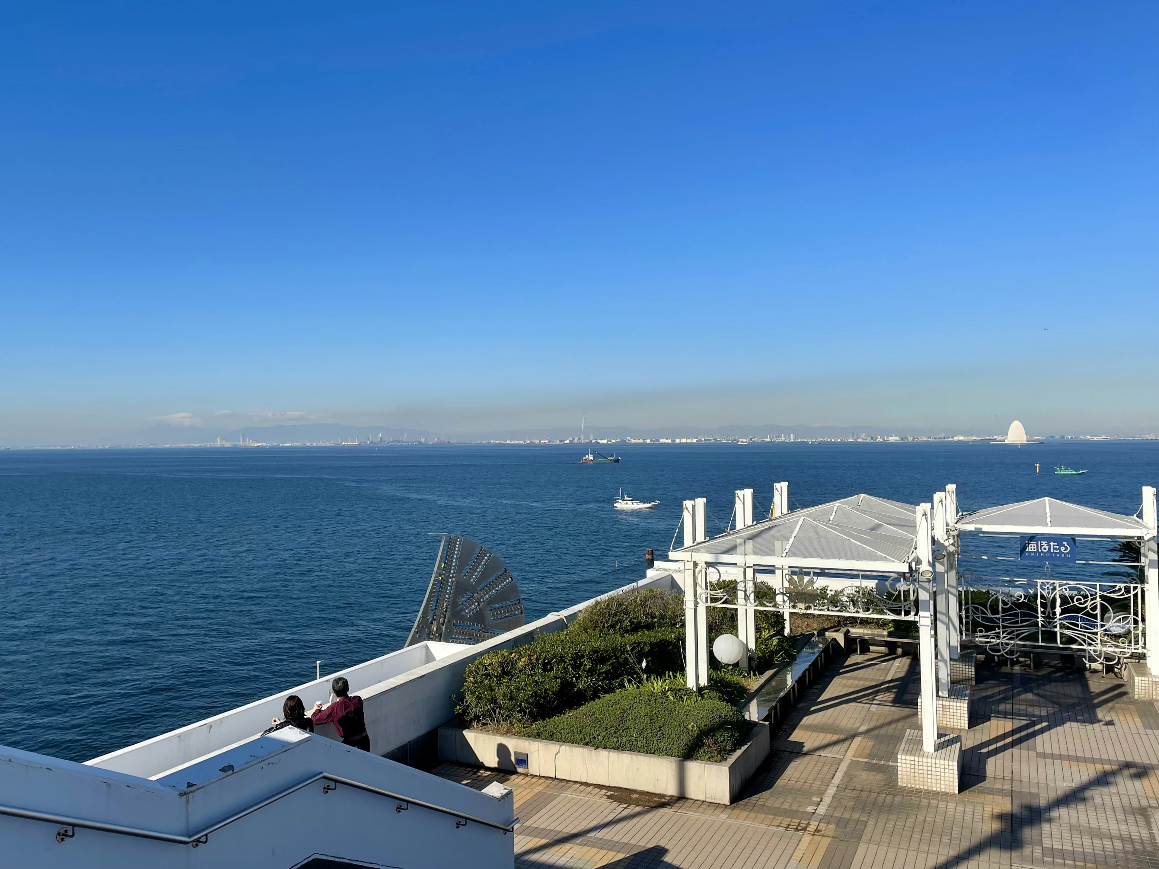 海と青空が広がる美しい風景に、屋外テラスが見える