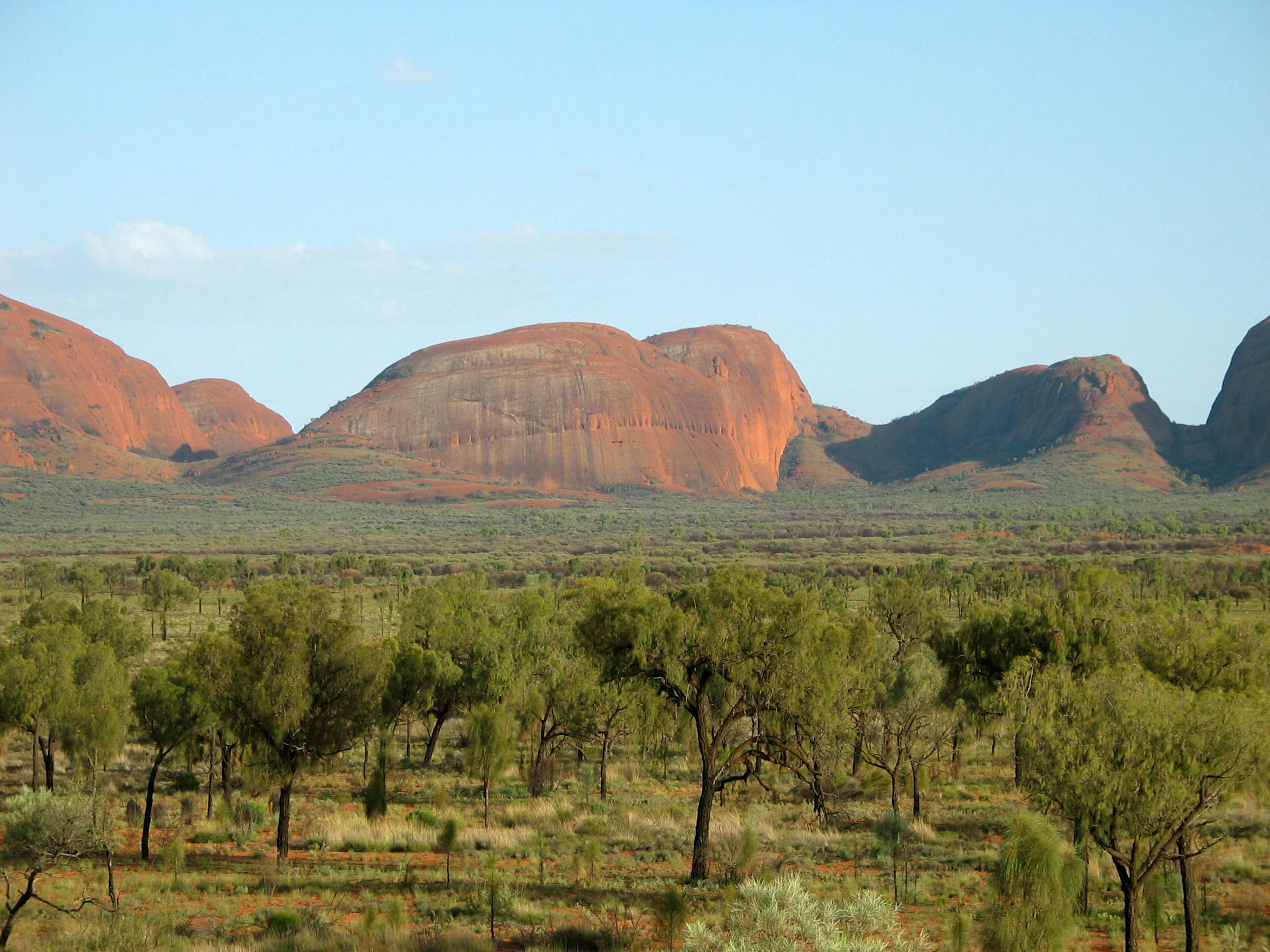 Red rock formations in an Australian landscape with scattered green trees