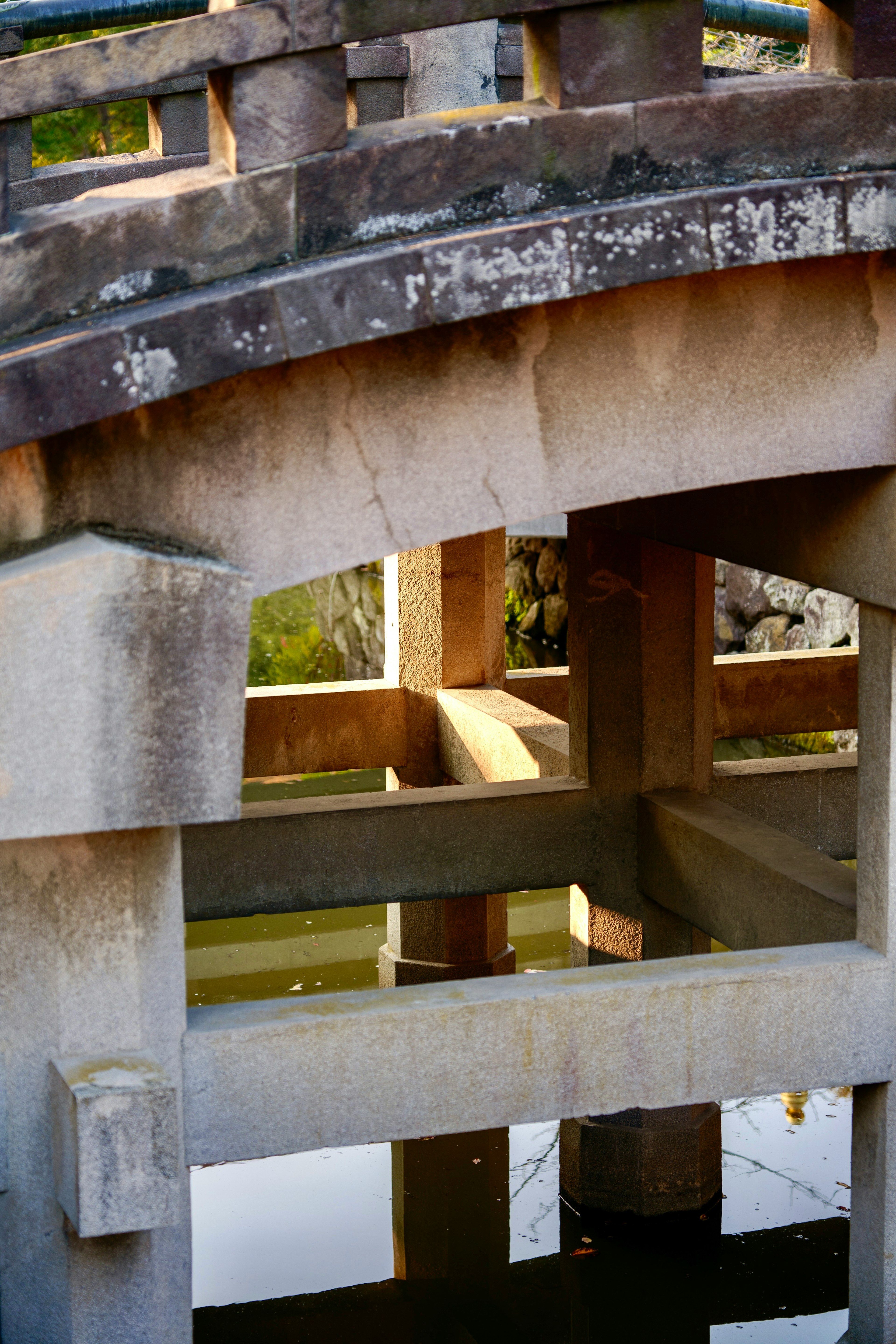 Primer plano de un viejo arco de piedra con reflejo en el agua