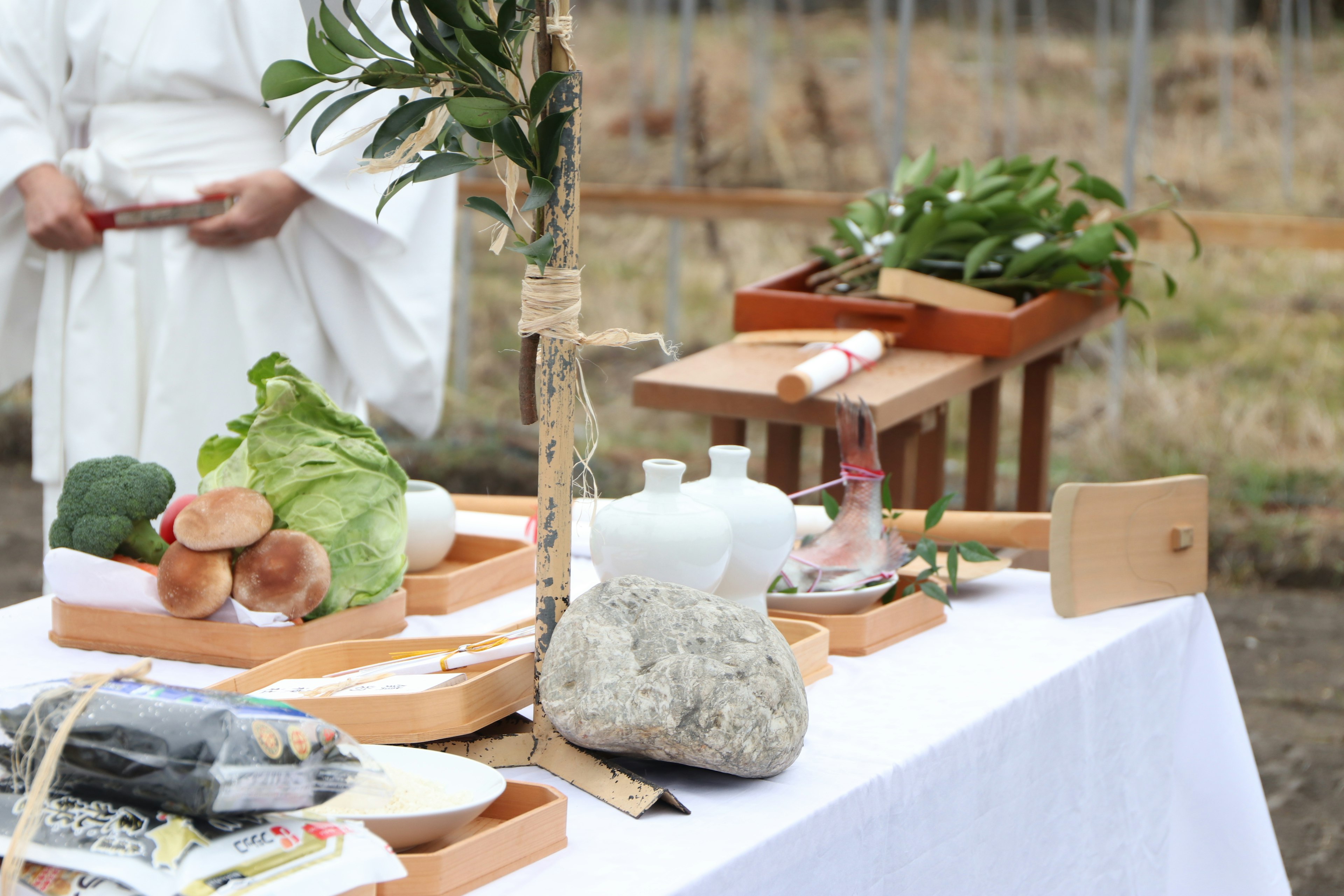 An altar with various offerings and tools on a white tablecloth