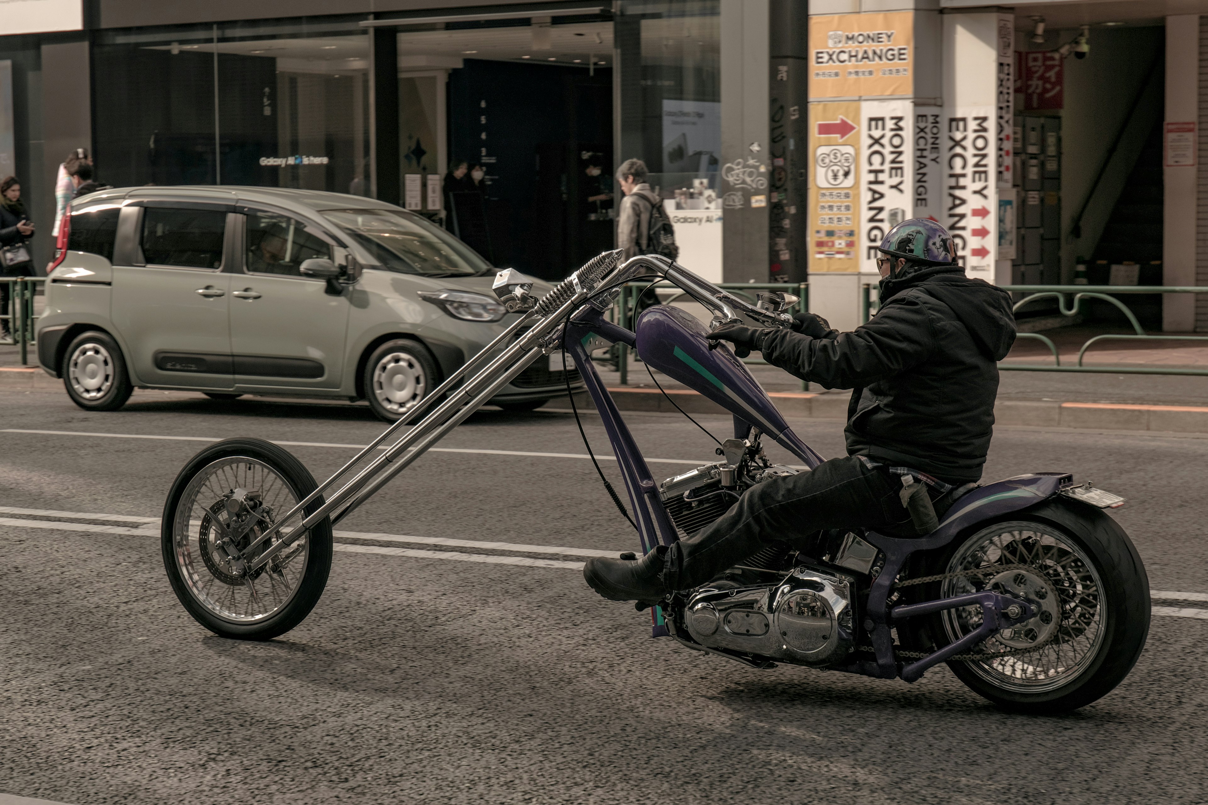 Motard sur une moto personnalisée avec de longues fourches avant circulant dans la rue