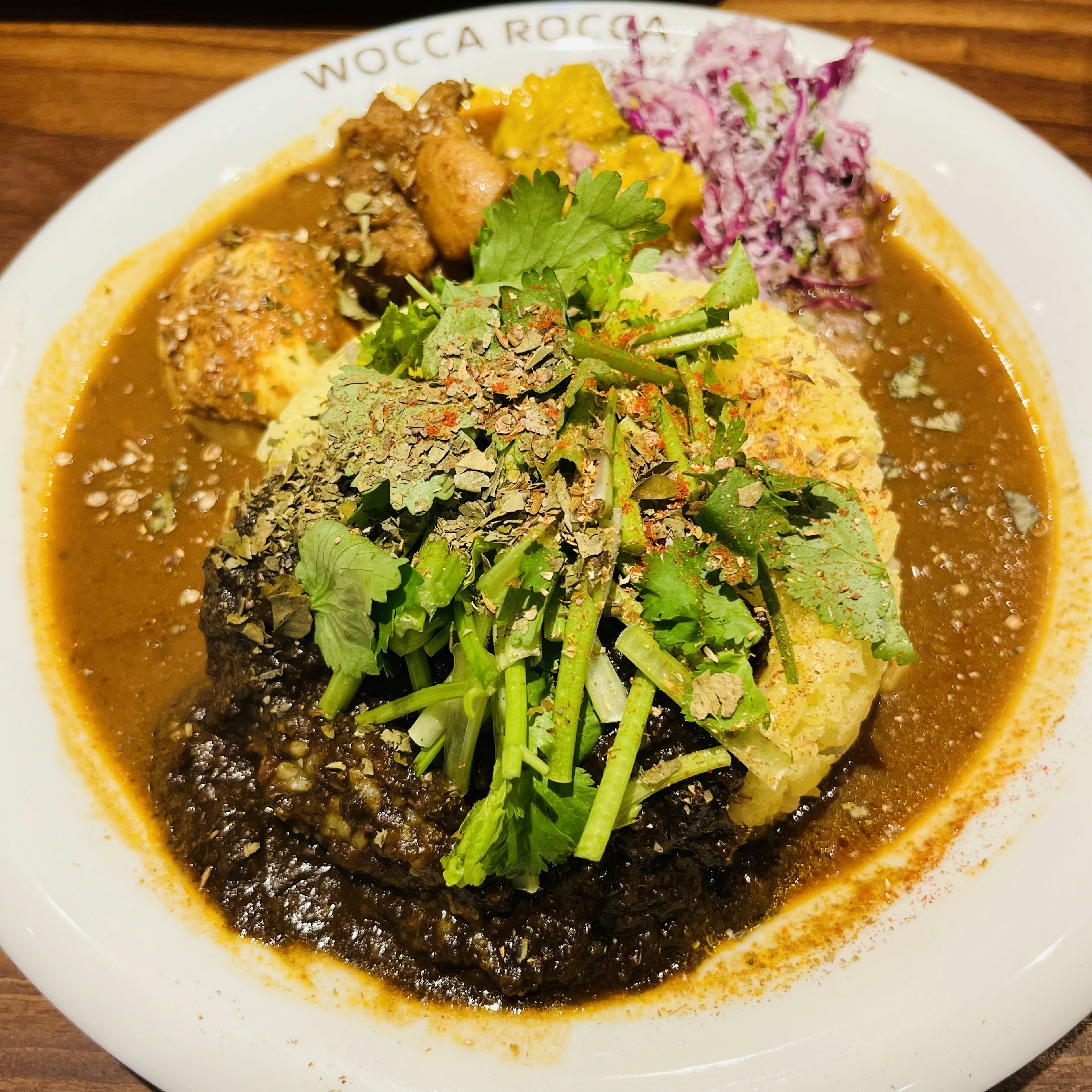 Plato con arroz cubierto de hierbas frescas y verduras en una salsa sabrosa