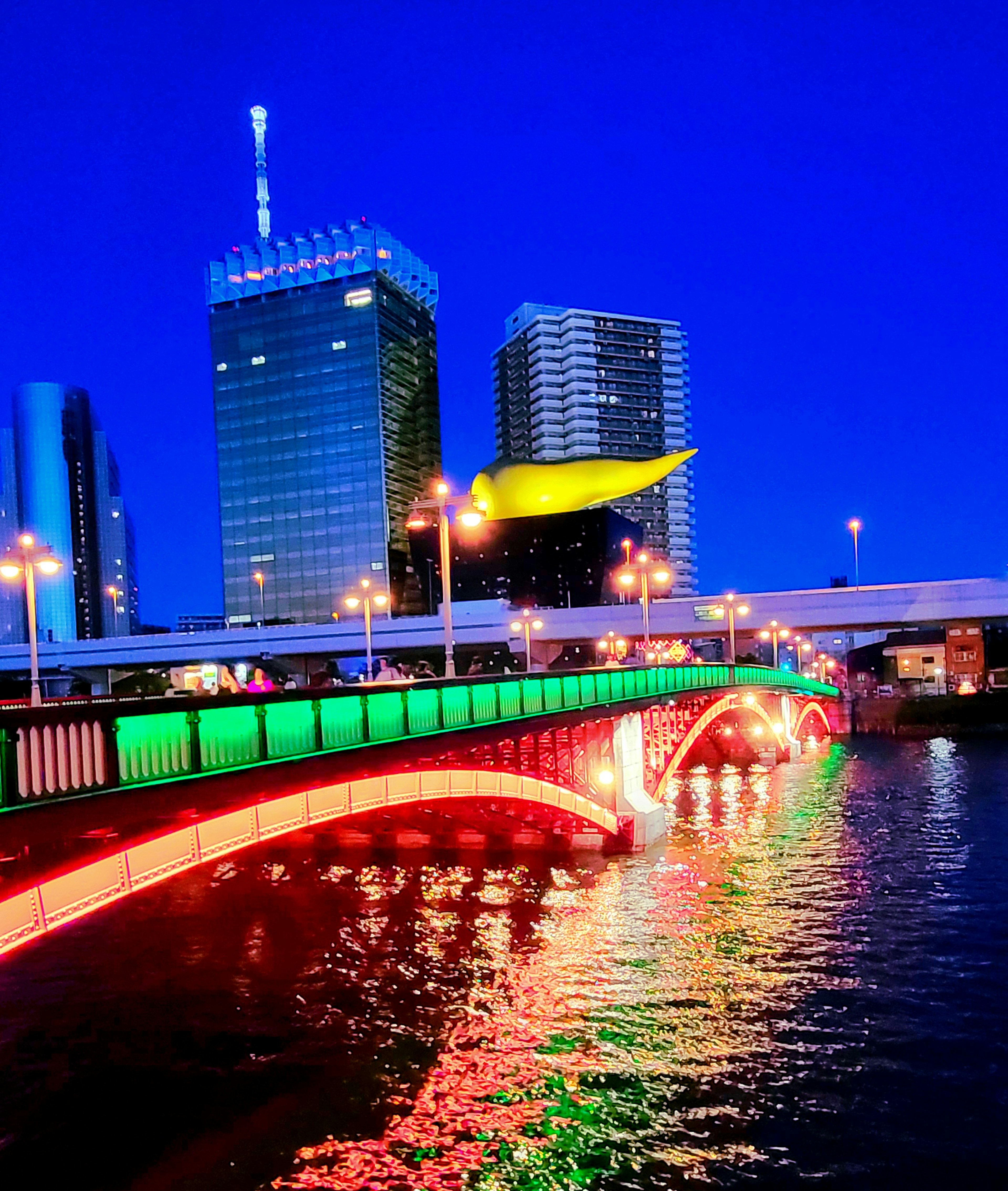 Pont coloré illuminé la nuit avec des gratte-ciels en arrière-plan