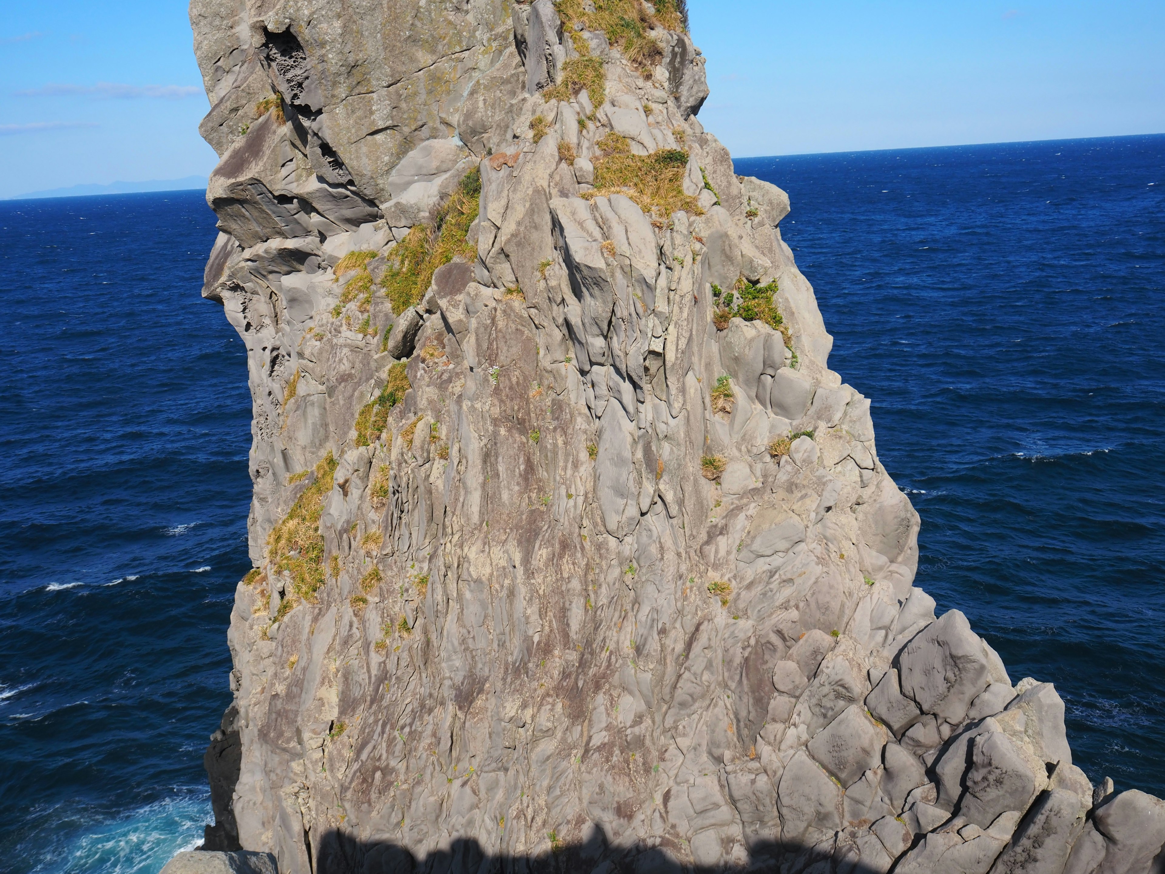 Large rock formation surrounded by the ocean