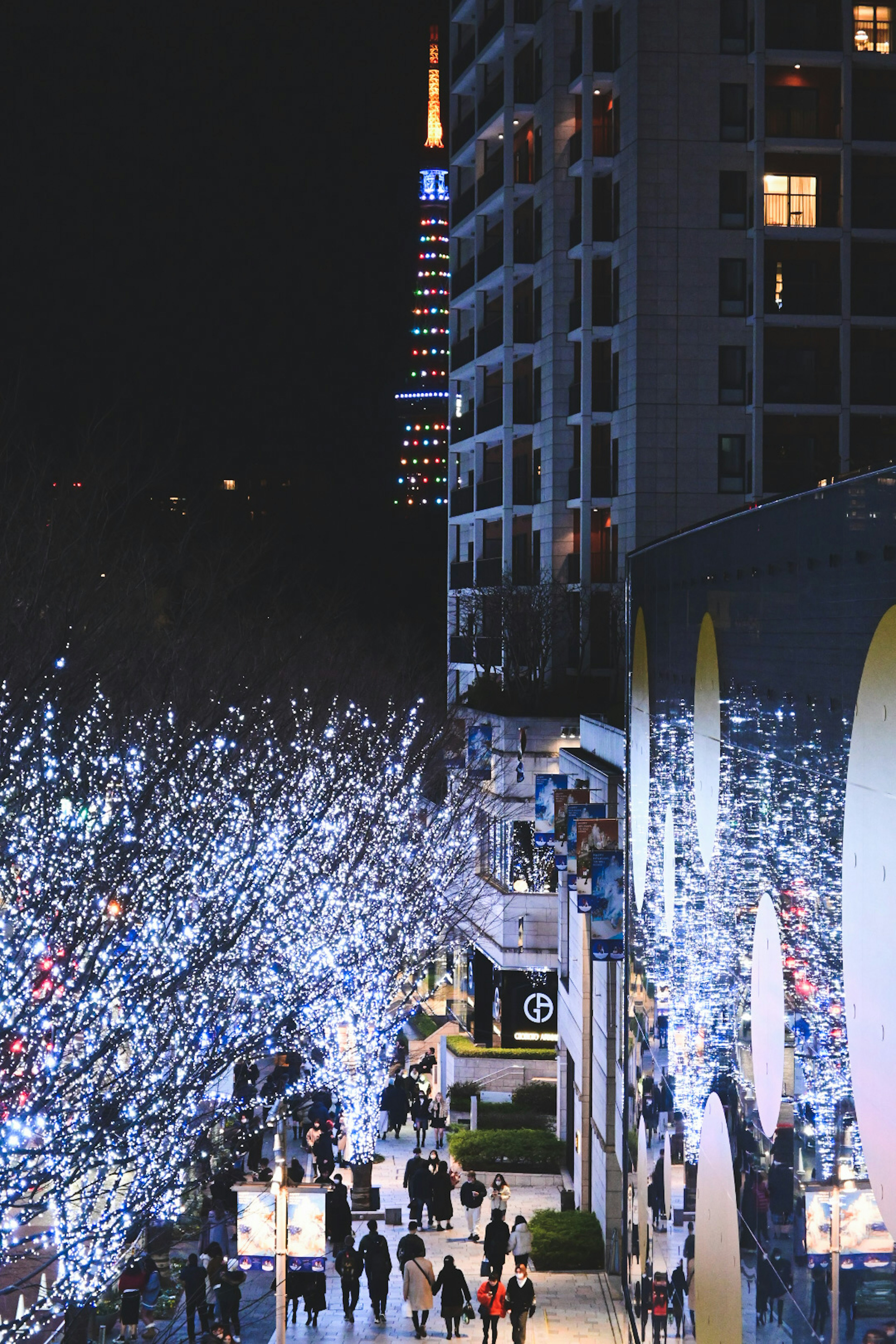 Paisaje urbano nocturno con luces blancas brillantes y personas