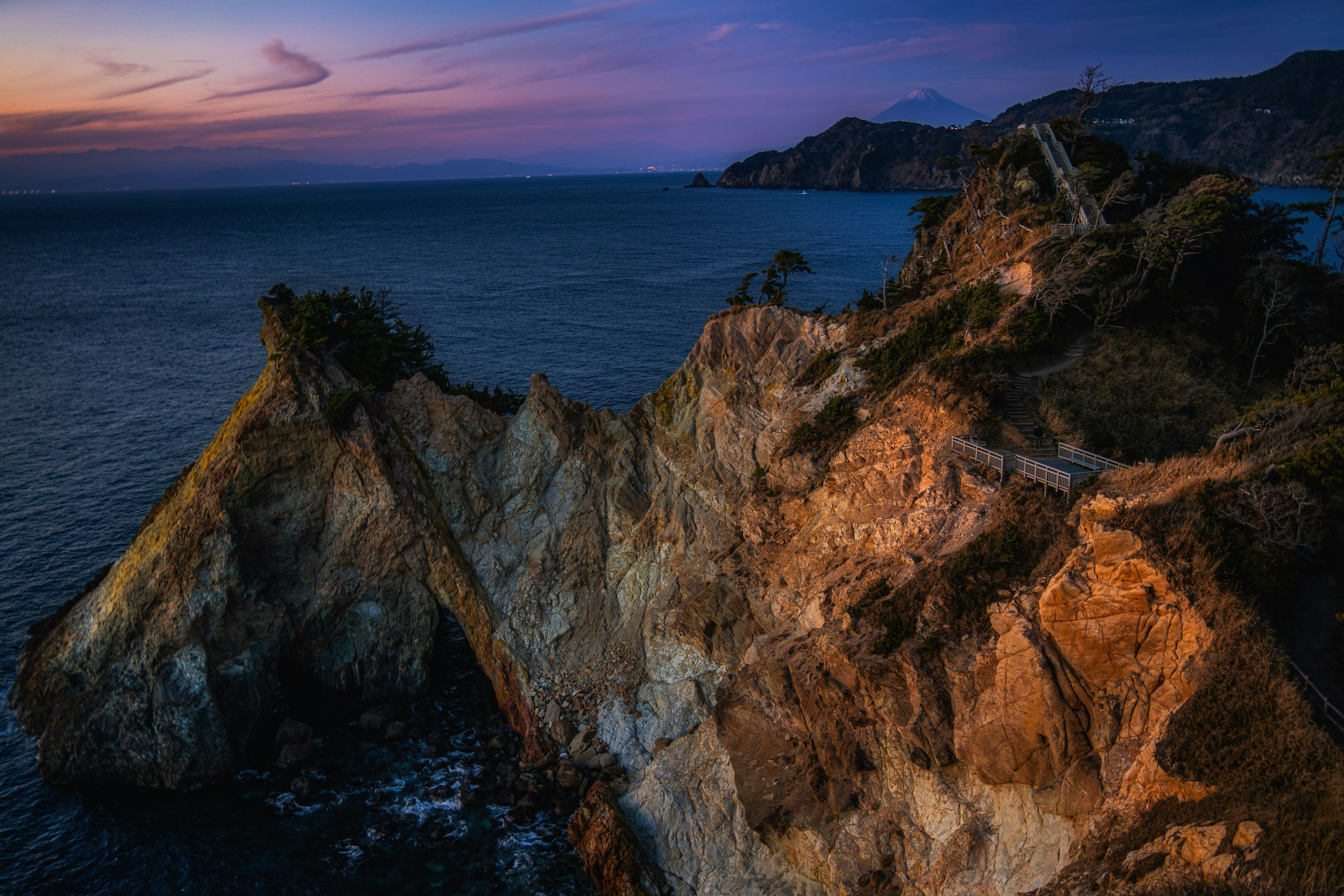 Paesaggio costiero al crepuscolo con scogliere impervie e oceano