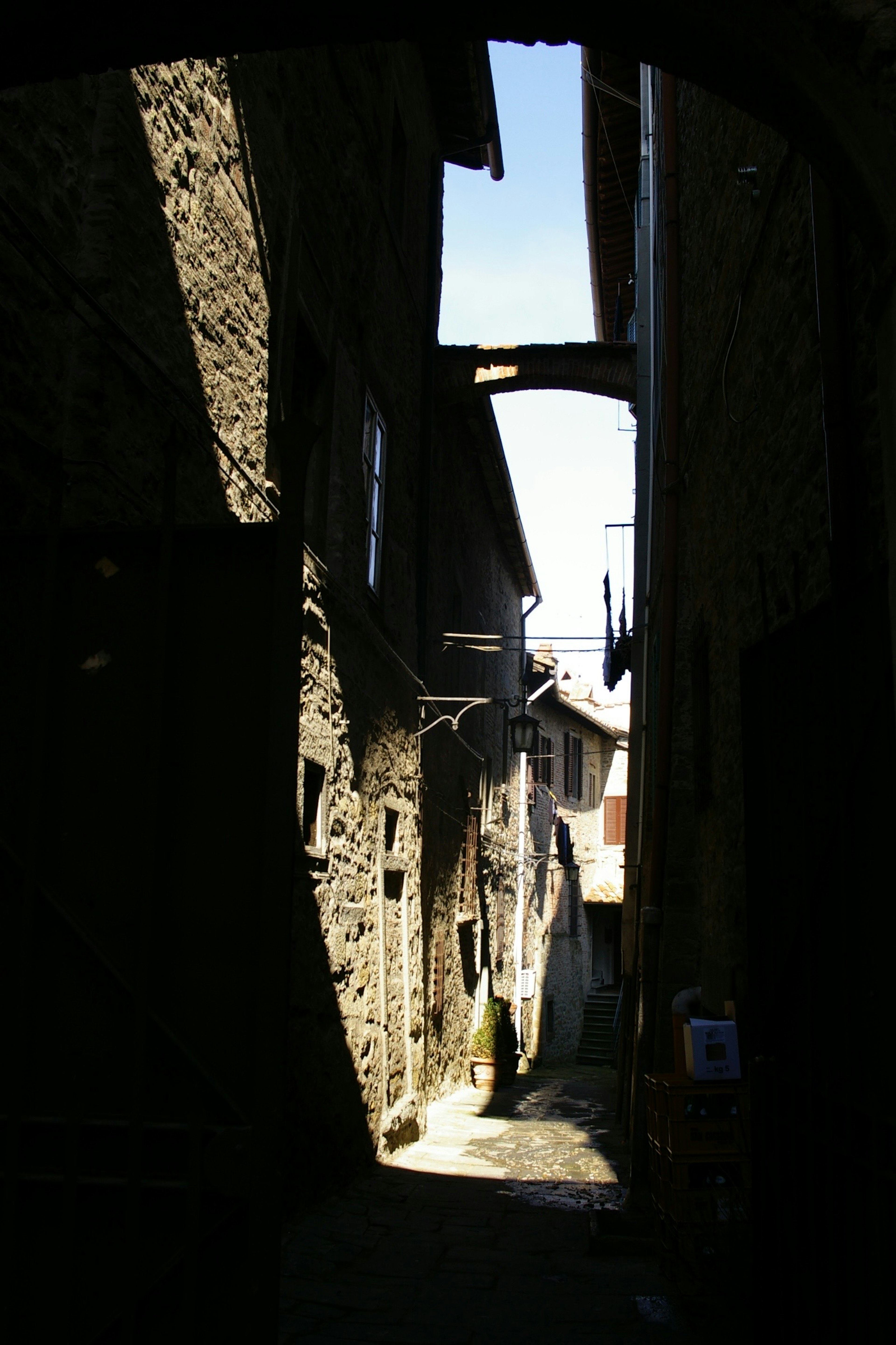 Narrow stone alley illuminated by light and shadow