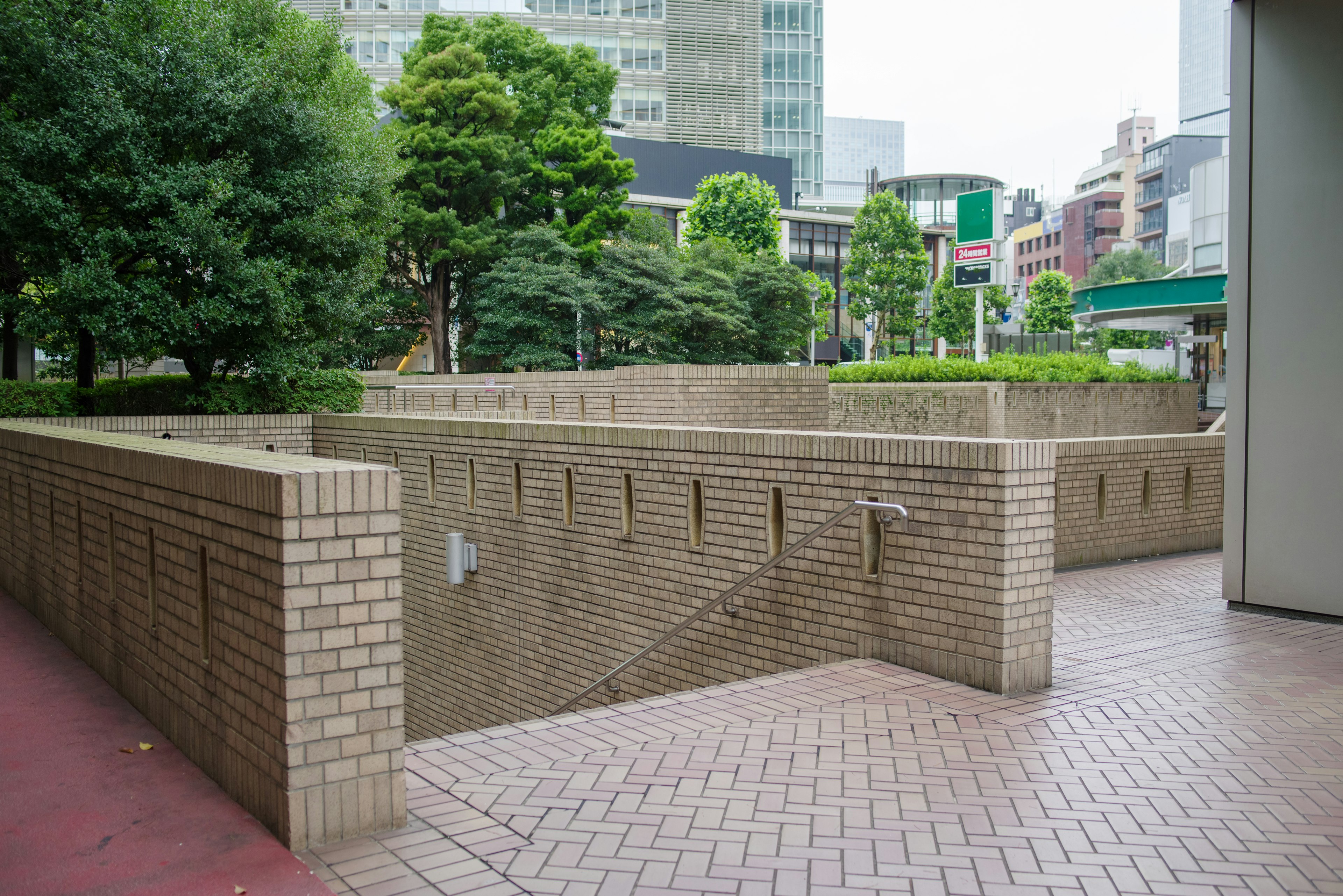 緑豊かな都市の風景とレンガ造りの歩道が見えるシーン