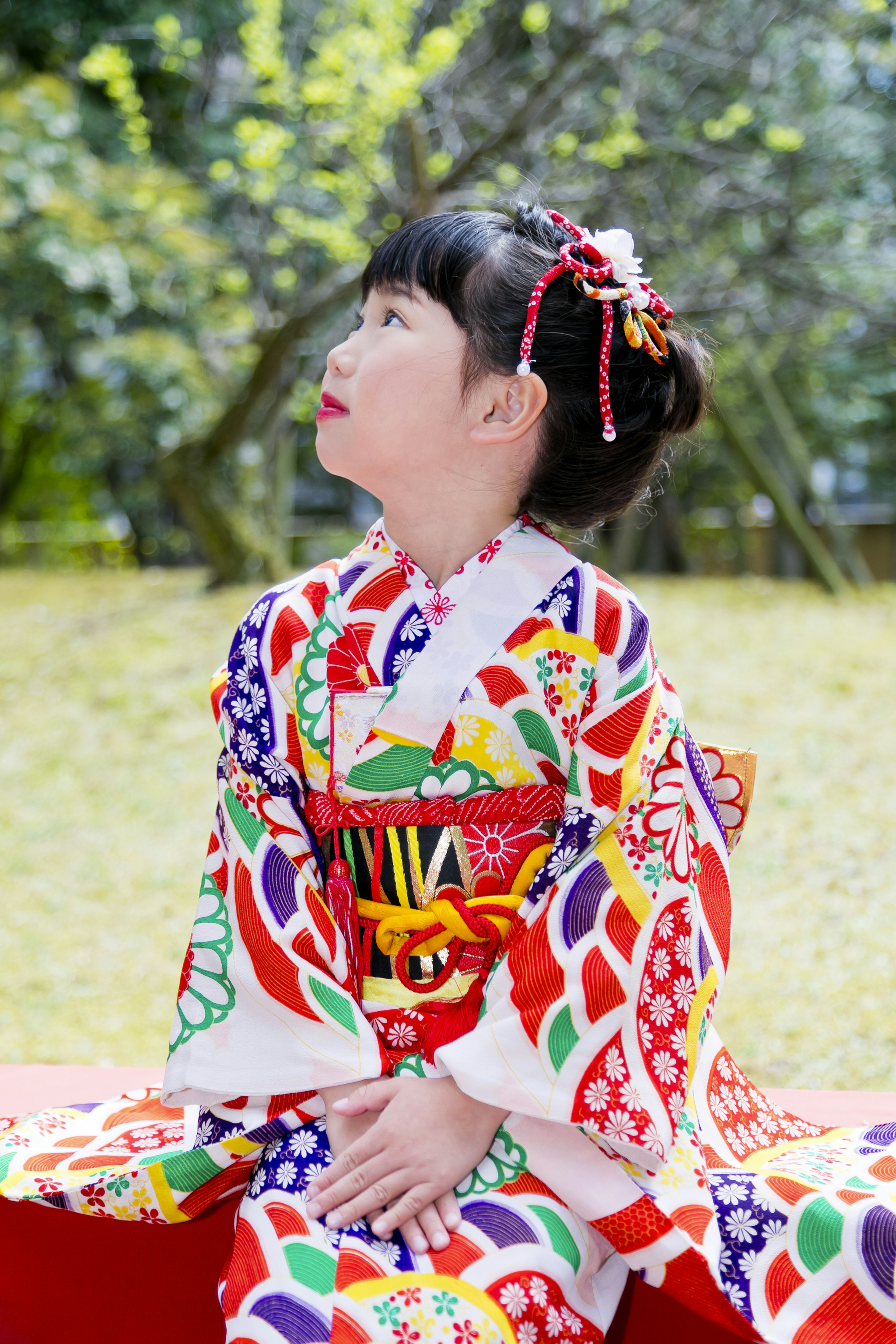 Ein Mädchen in einem bunten Kimono, das zum Himmel schaut