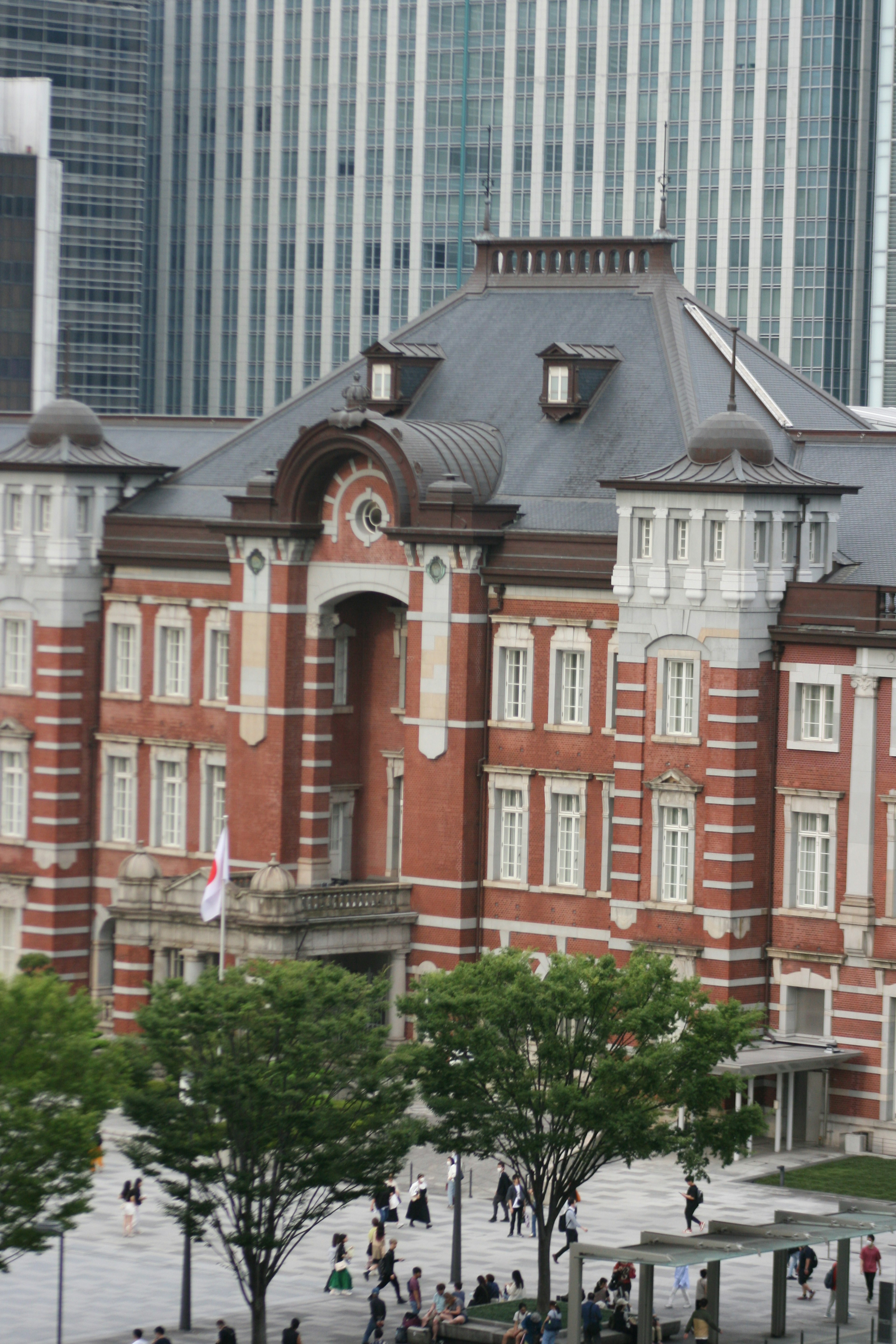 Stazione di Tokyo con architettura in mattoni rossi e grattacieli moderni