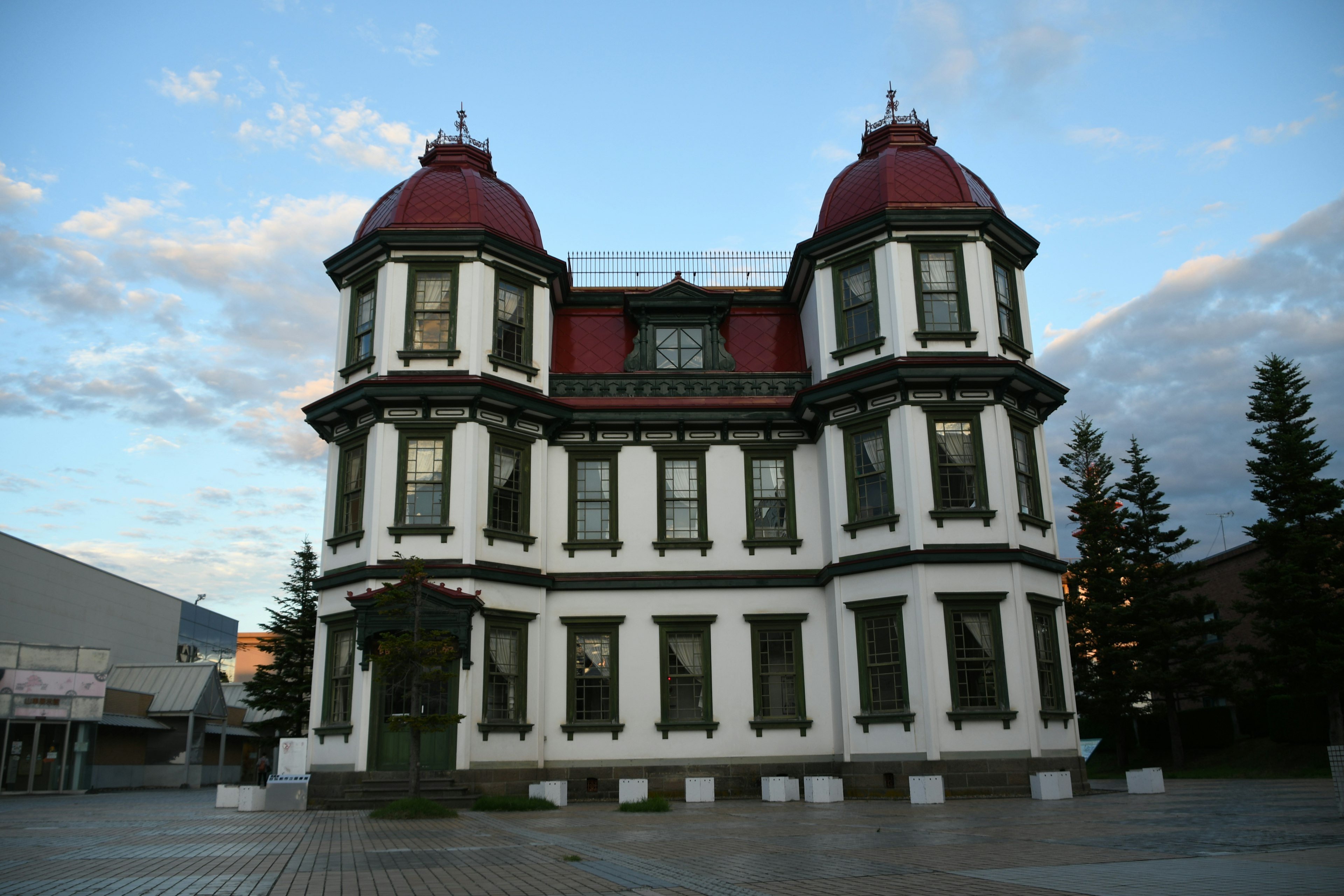 Weißes Gebäude mit roten Kuppeldächern und großen Fenstern