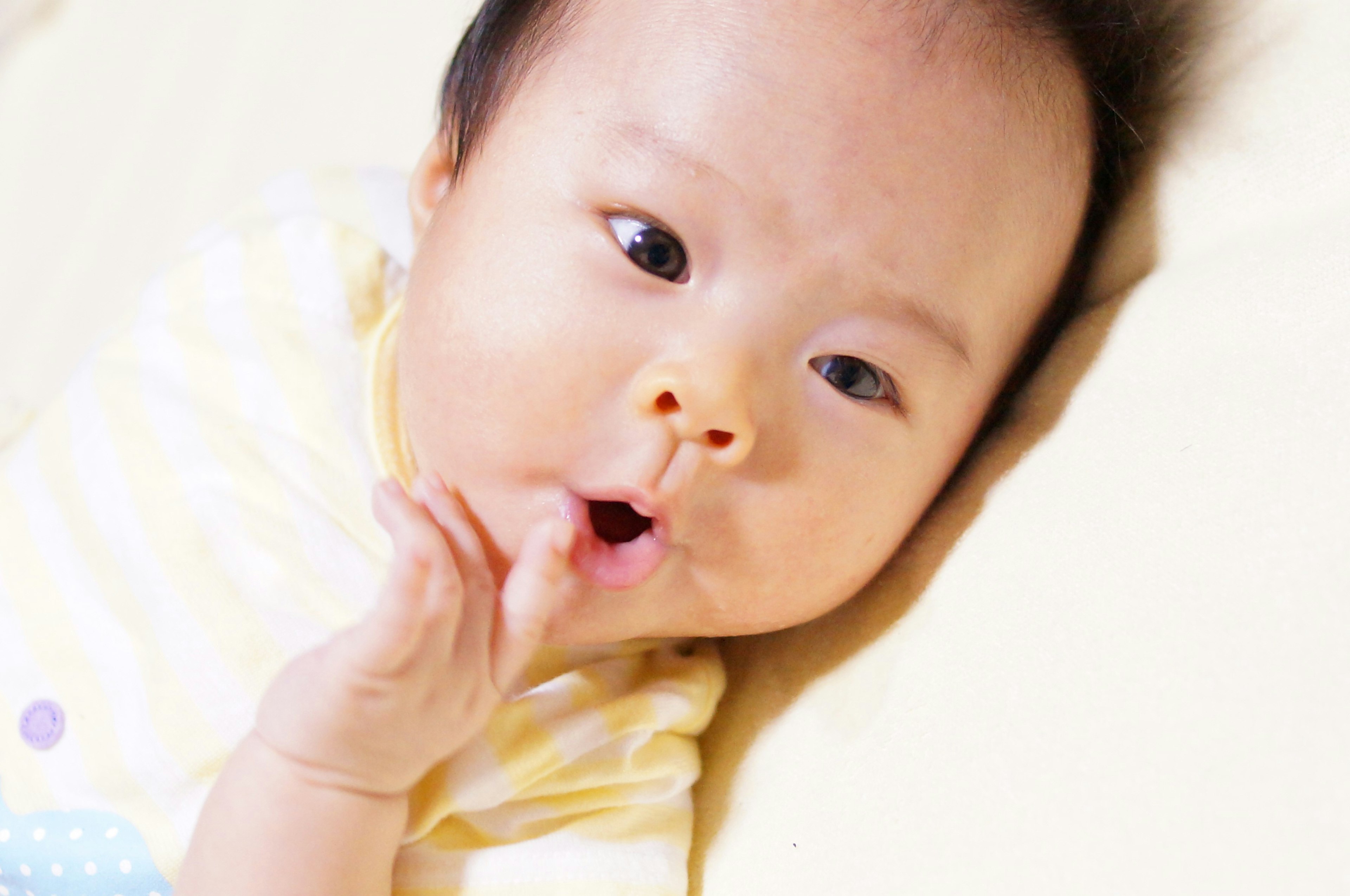 Bébé avec une expression surprise et une main près de la bouche