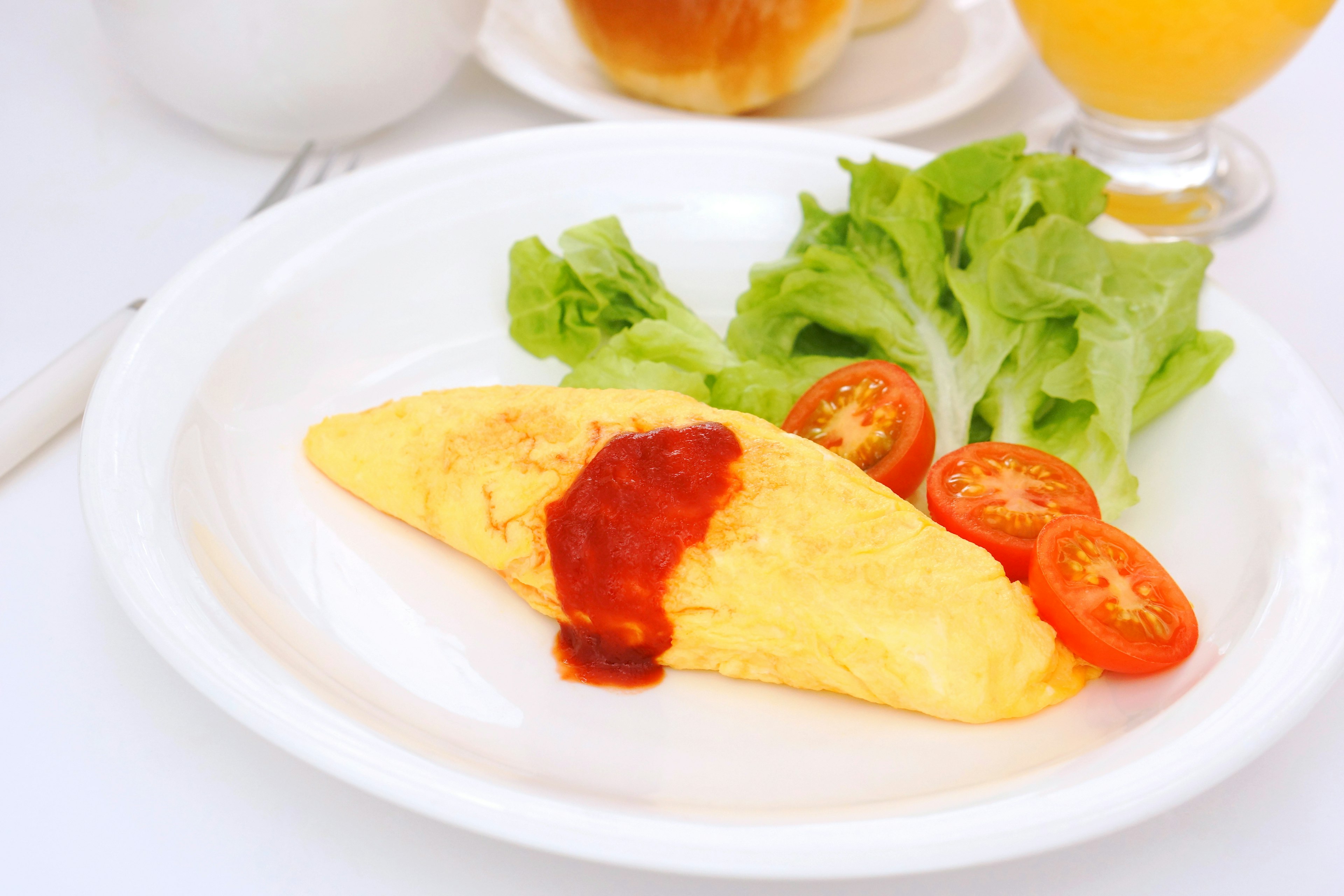 Teller mit Omelette, serviert mit Salat und Kirschtomaten