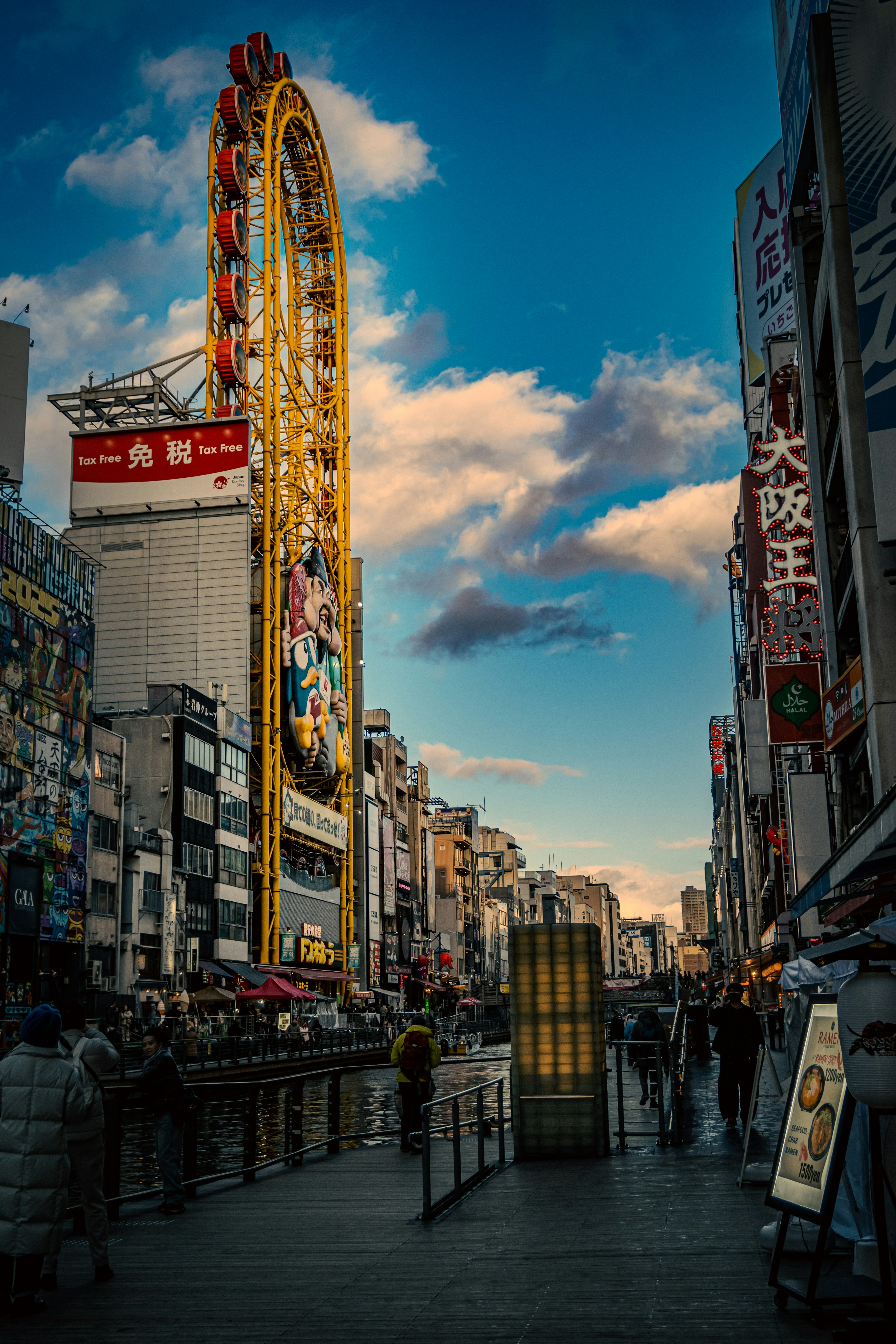 Vibrant city street featuring a tall neon sign and blue sky