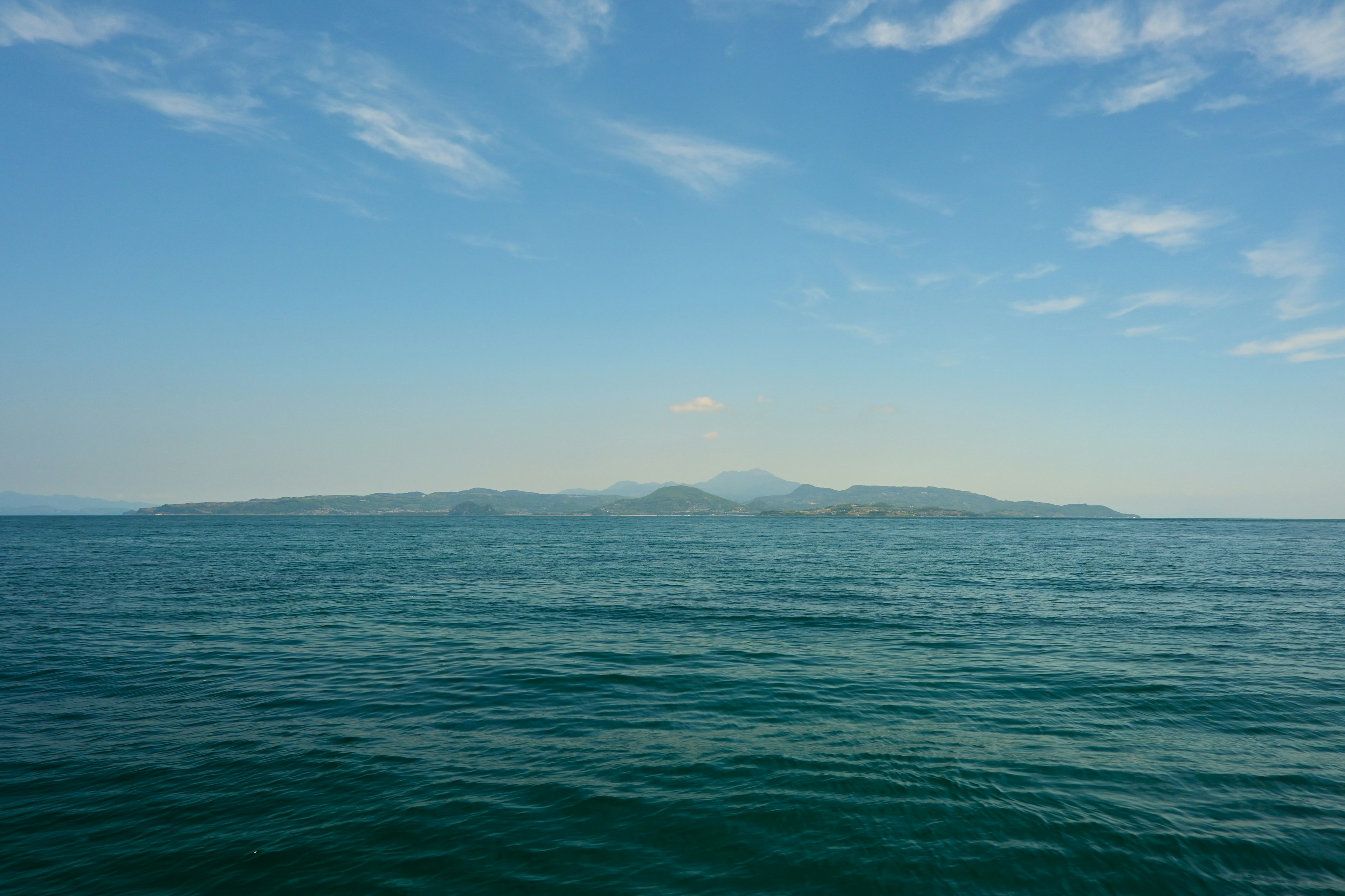 青い海と空の景色に浮かぶ島のシルエット