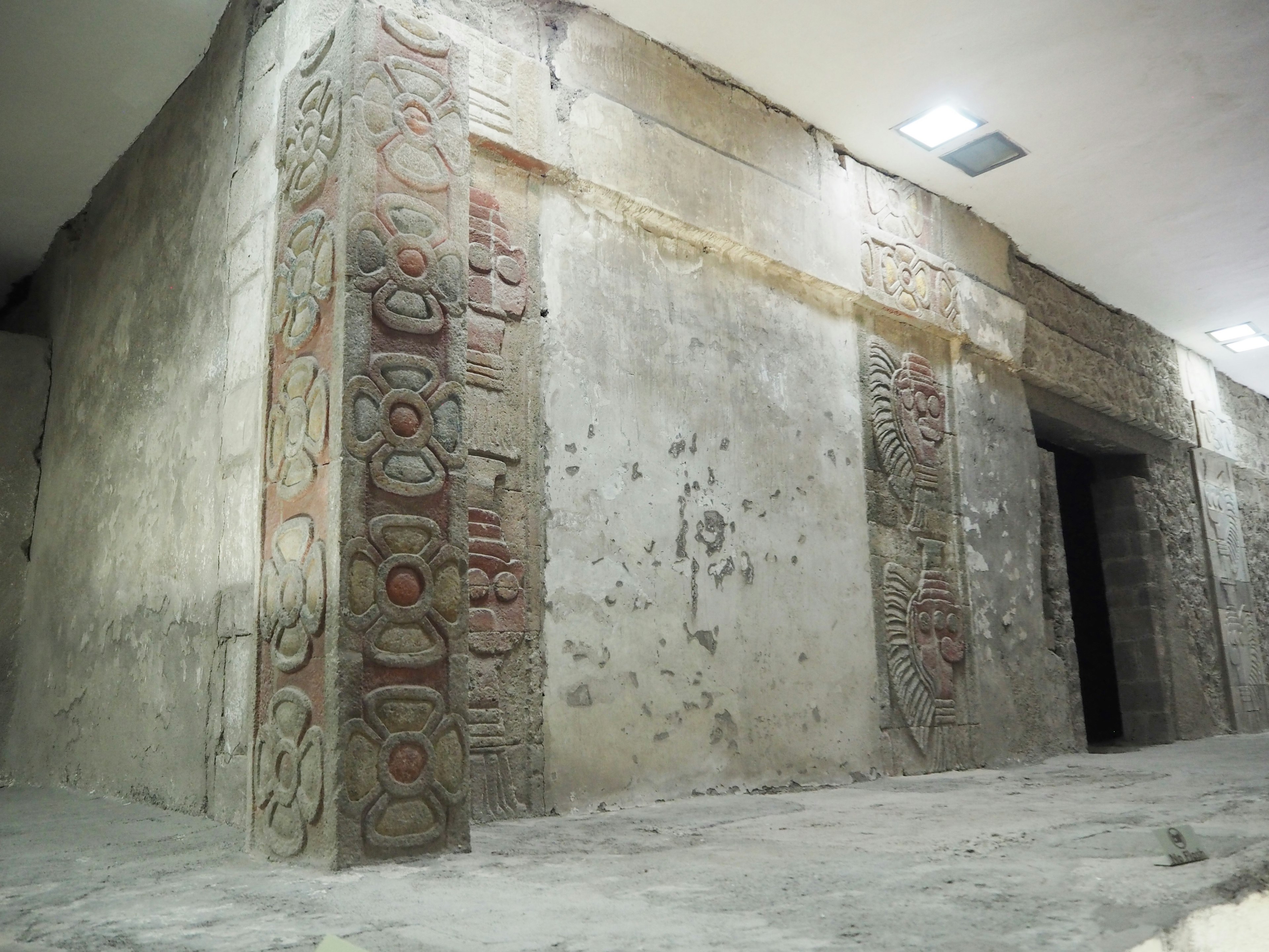 Intérieur d'une pièce avec des gravures murales anciennes et des murs en pierre