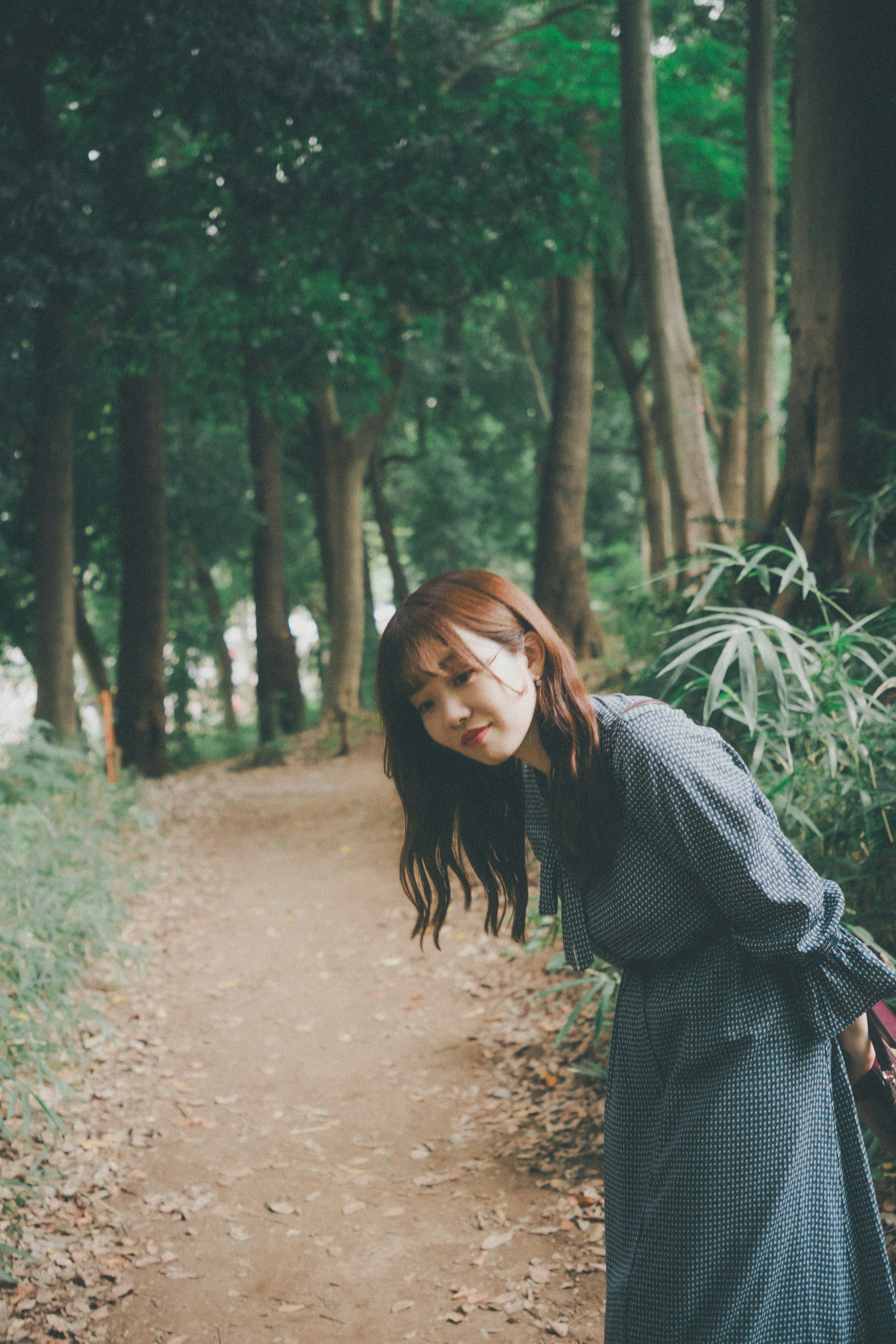 A woman smiling in a green forest path