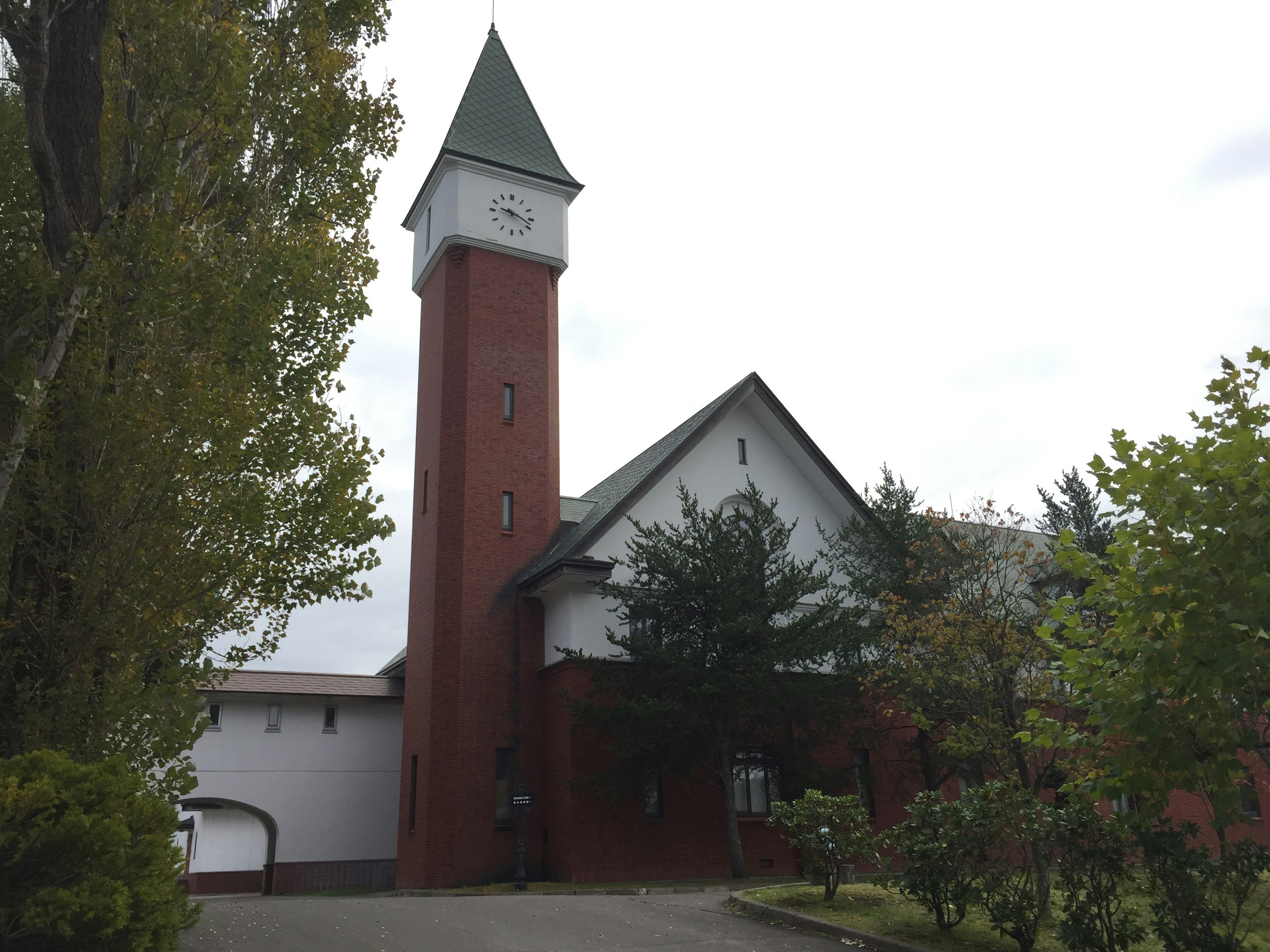 Extérieur d'une église avec un bâtiment en brique rouge et un toit vert