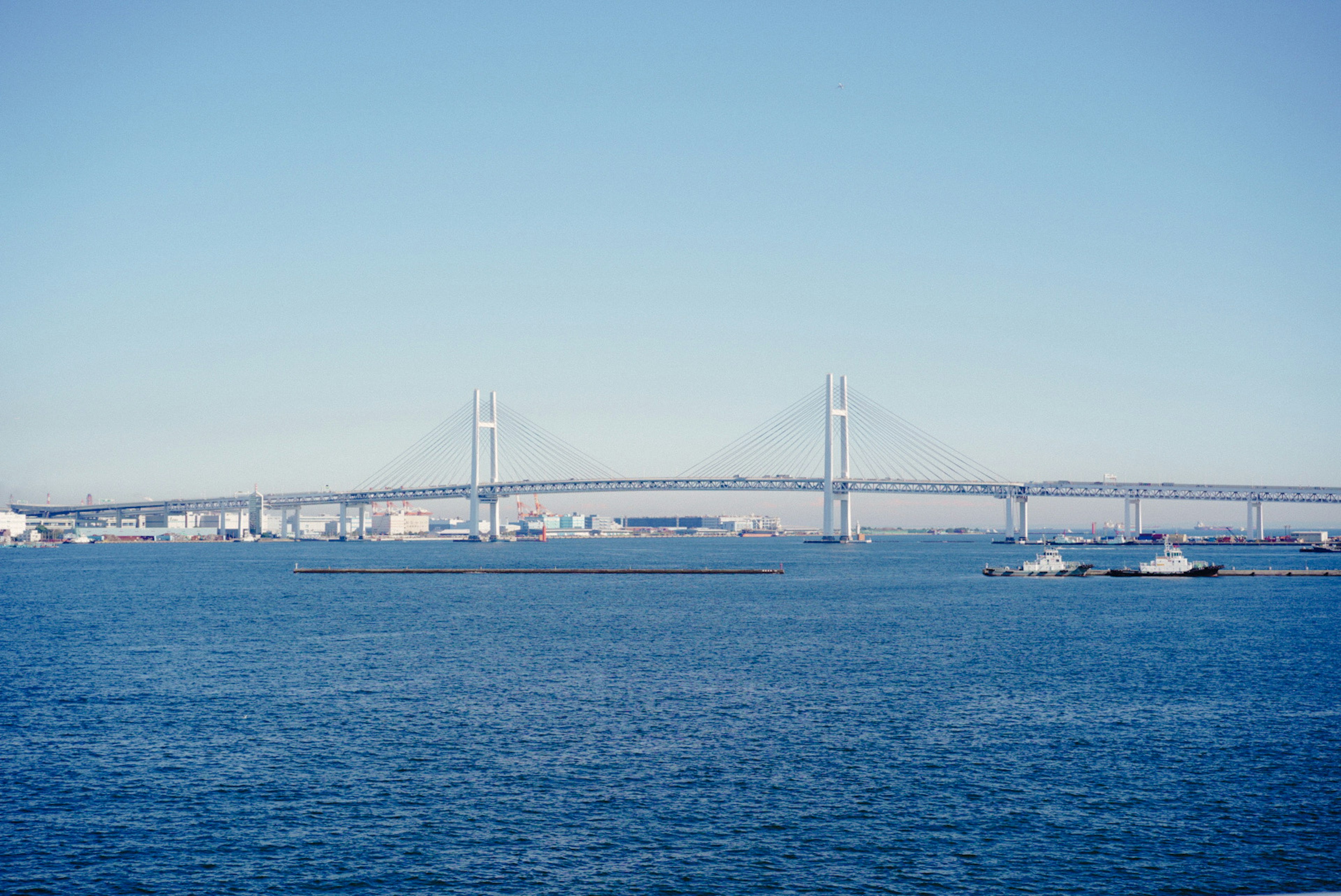 Malersicher Blick auf eine Brücke über Wasser unter einem klaren blauen Himmel