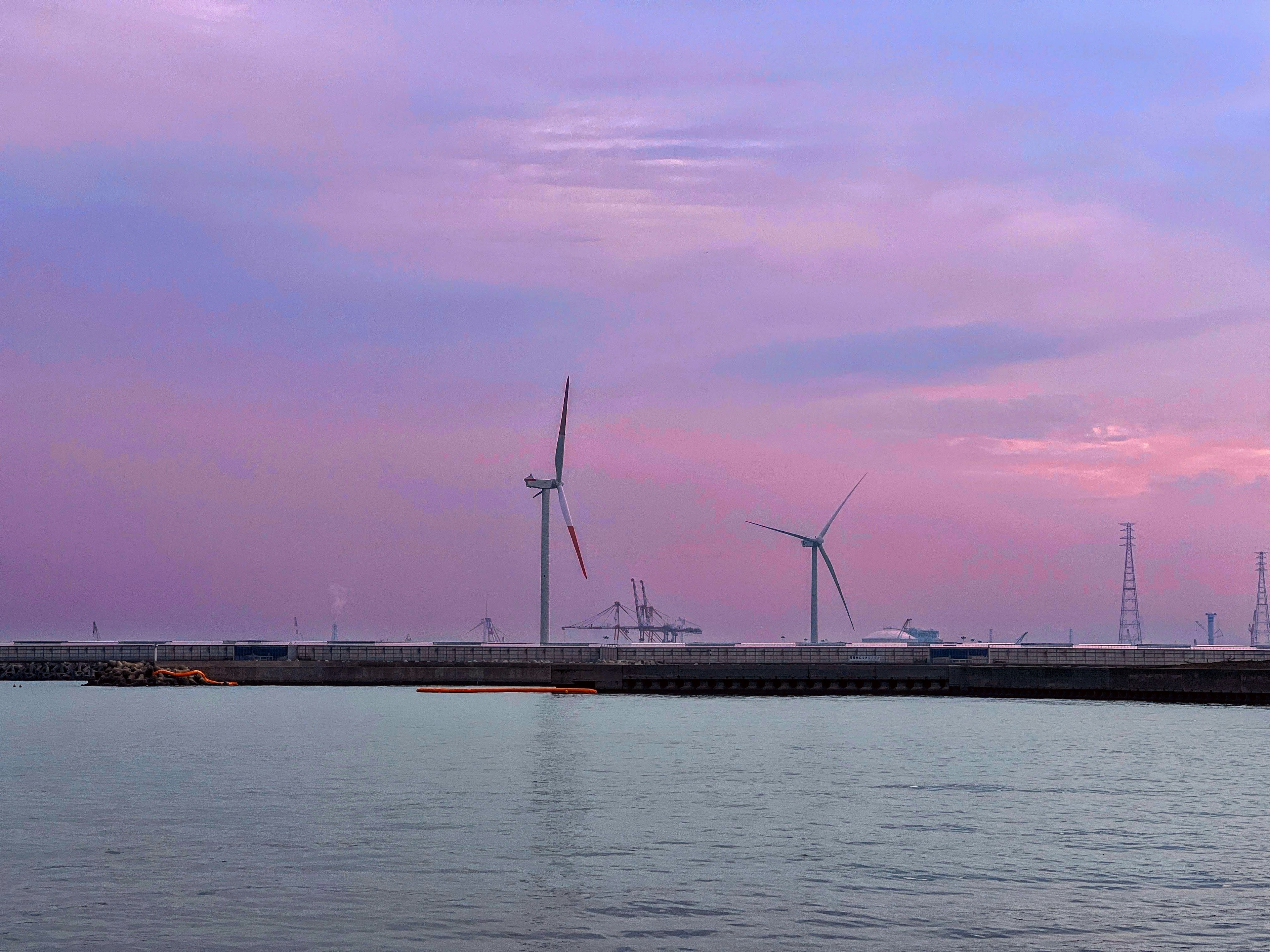 風力発電機が並ぶ海岸の美しい夕焼け