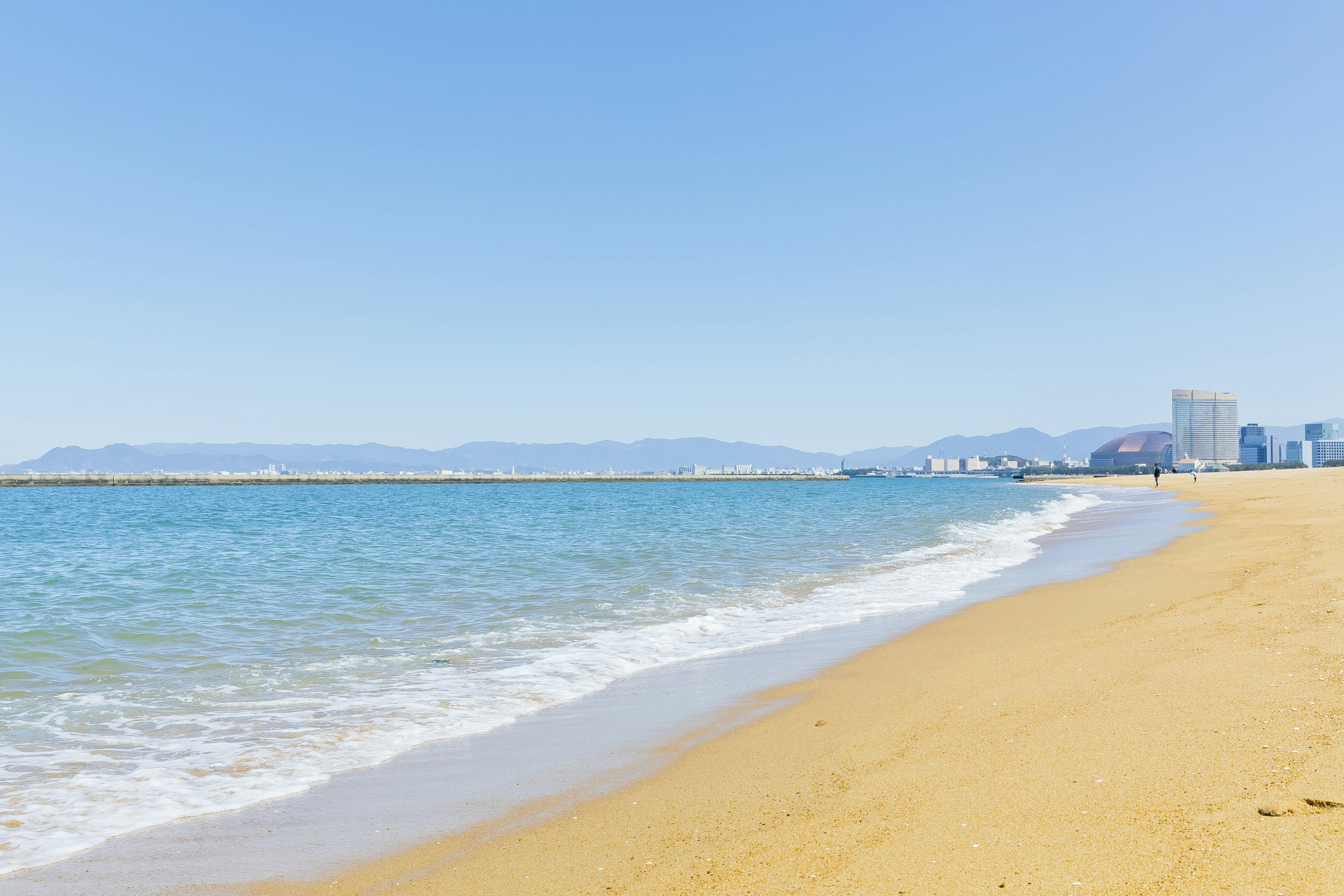 Vista de playa escénica con cielo azul y olas suaves