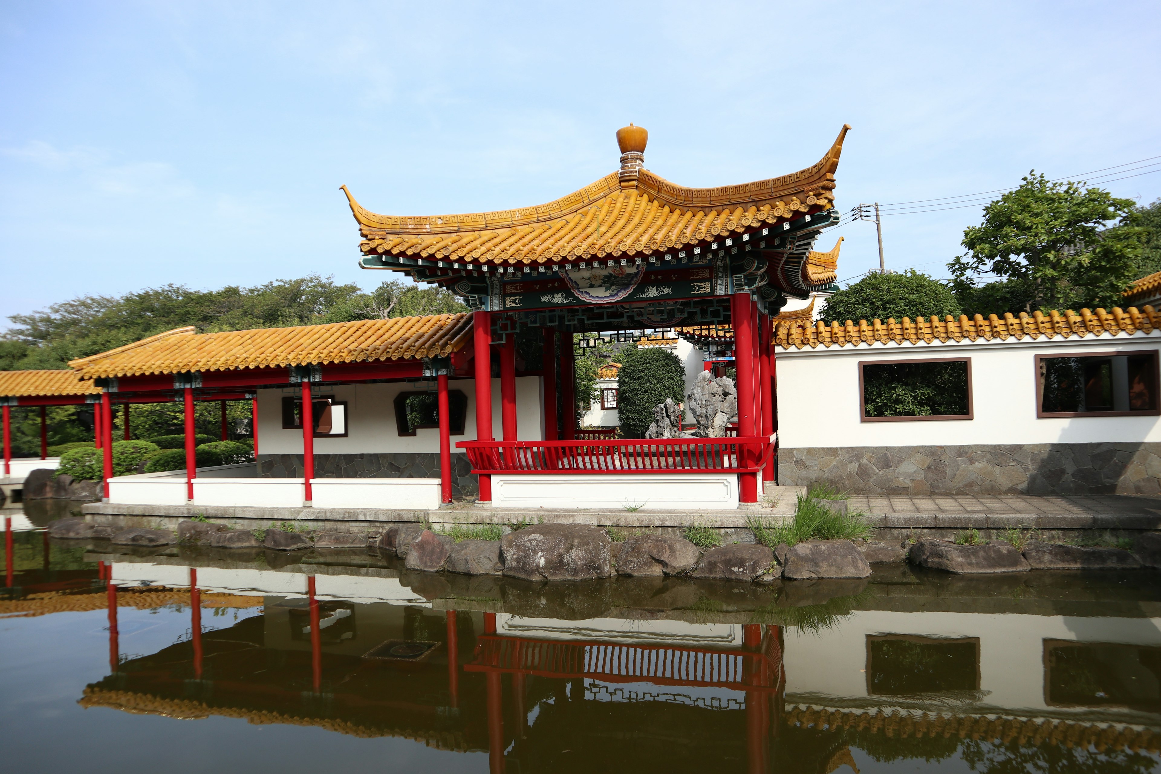 Beautiful Chinese-style building stands by the edge of a pond