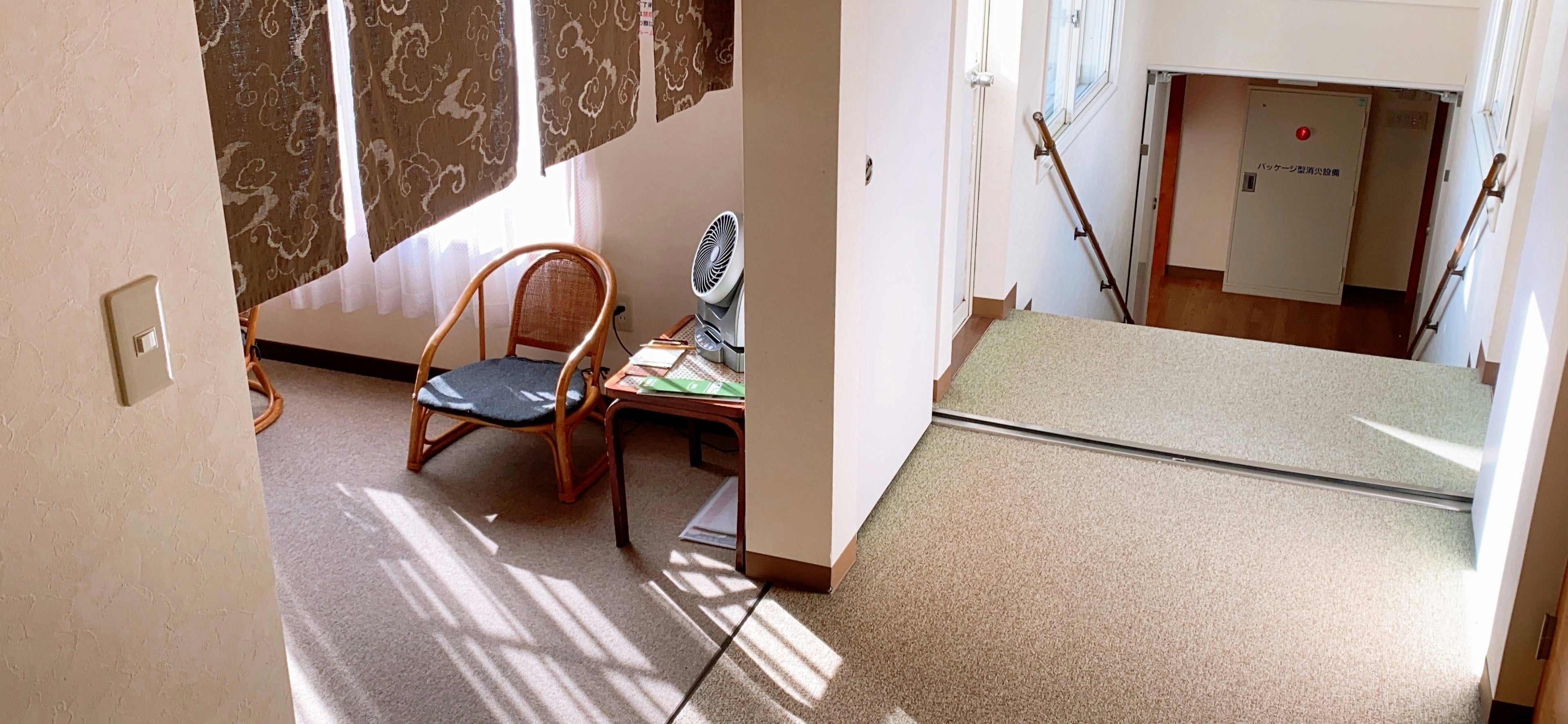 A hallway scene featuring a chair and table in a bright indoor setting