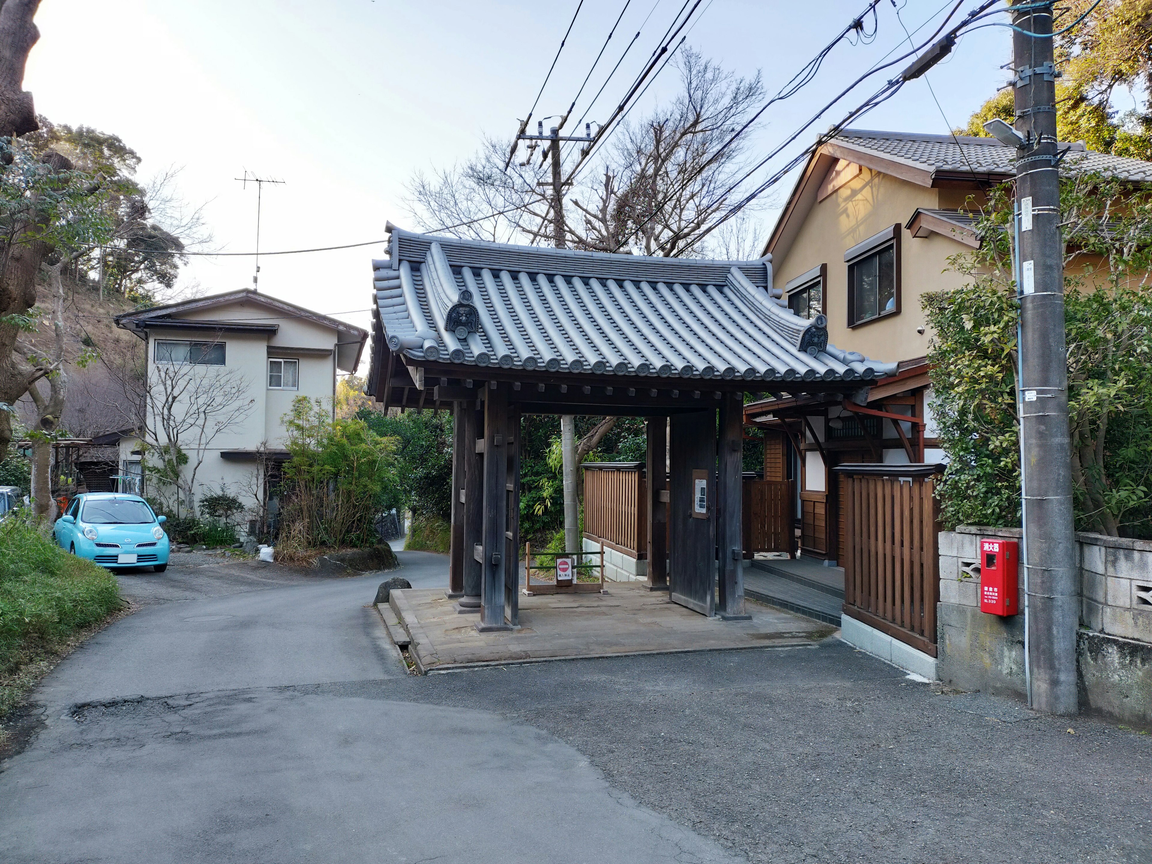 Traditionelles japanisches Tor mit umliegenden Häusern in einer ruhigen Straße