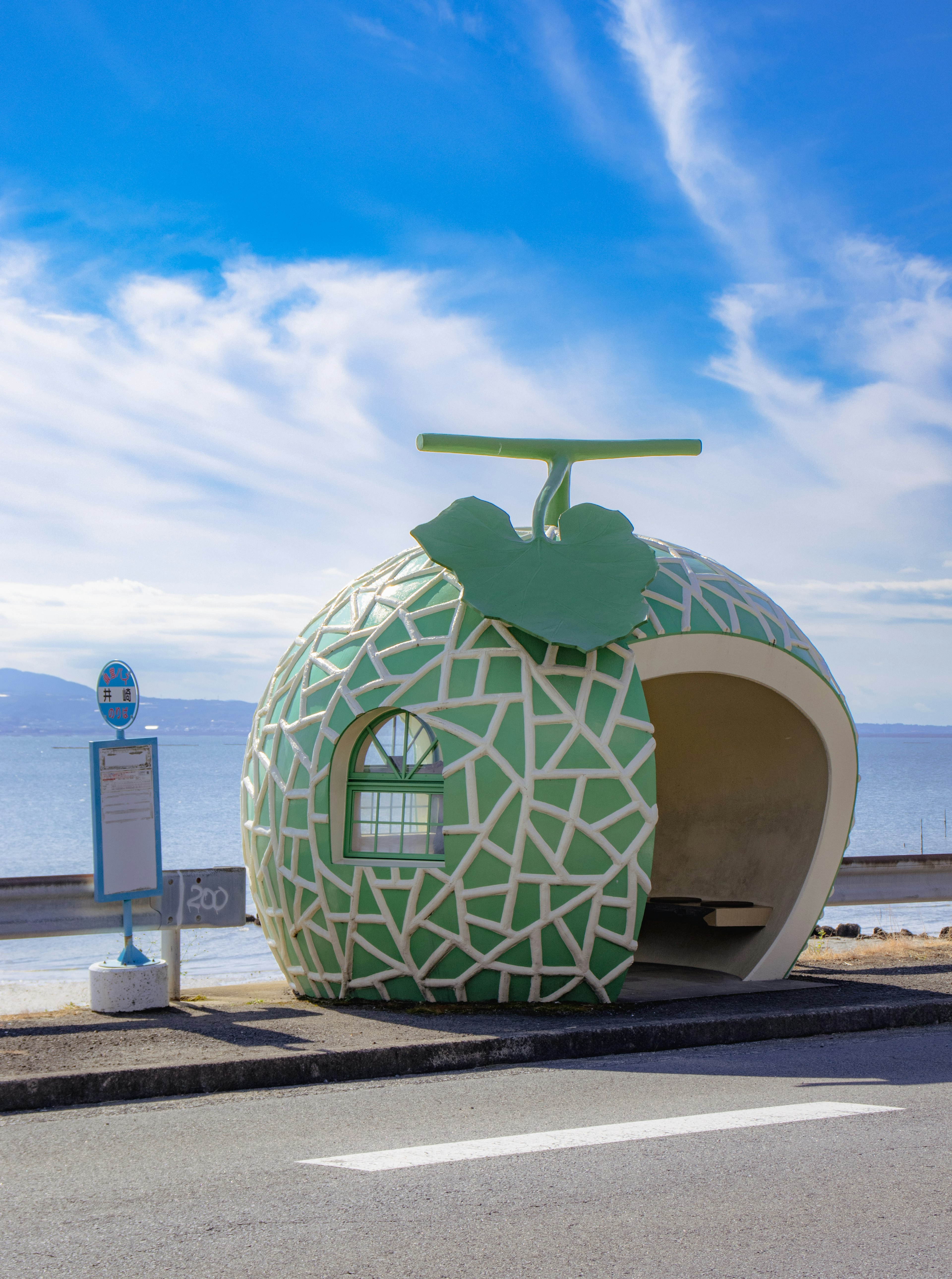 Unique fruit-shaped bus stop under a blue sky