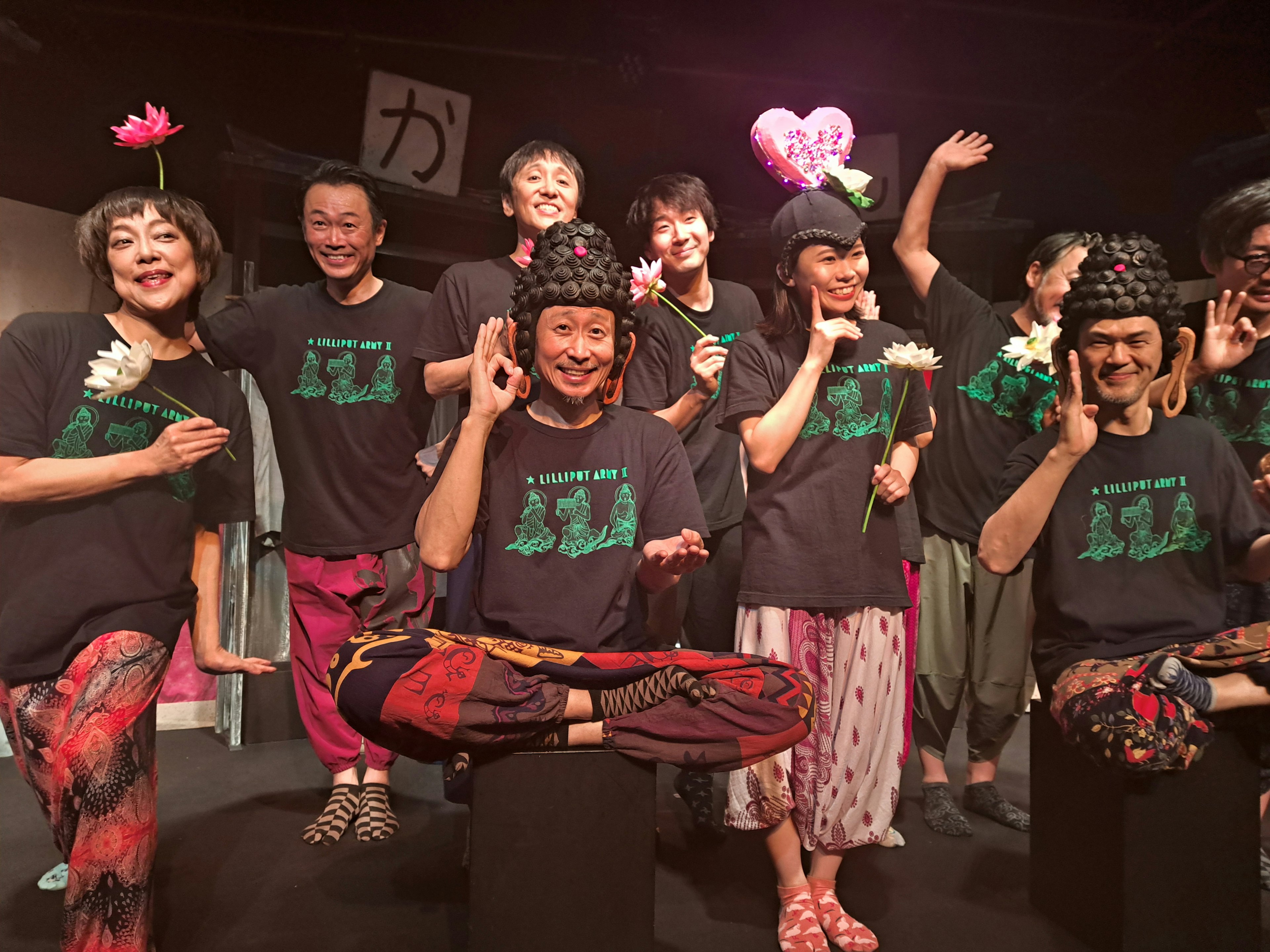 Gruppo di performer in costumi colorati che posano con sorrisi e accessori