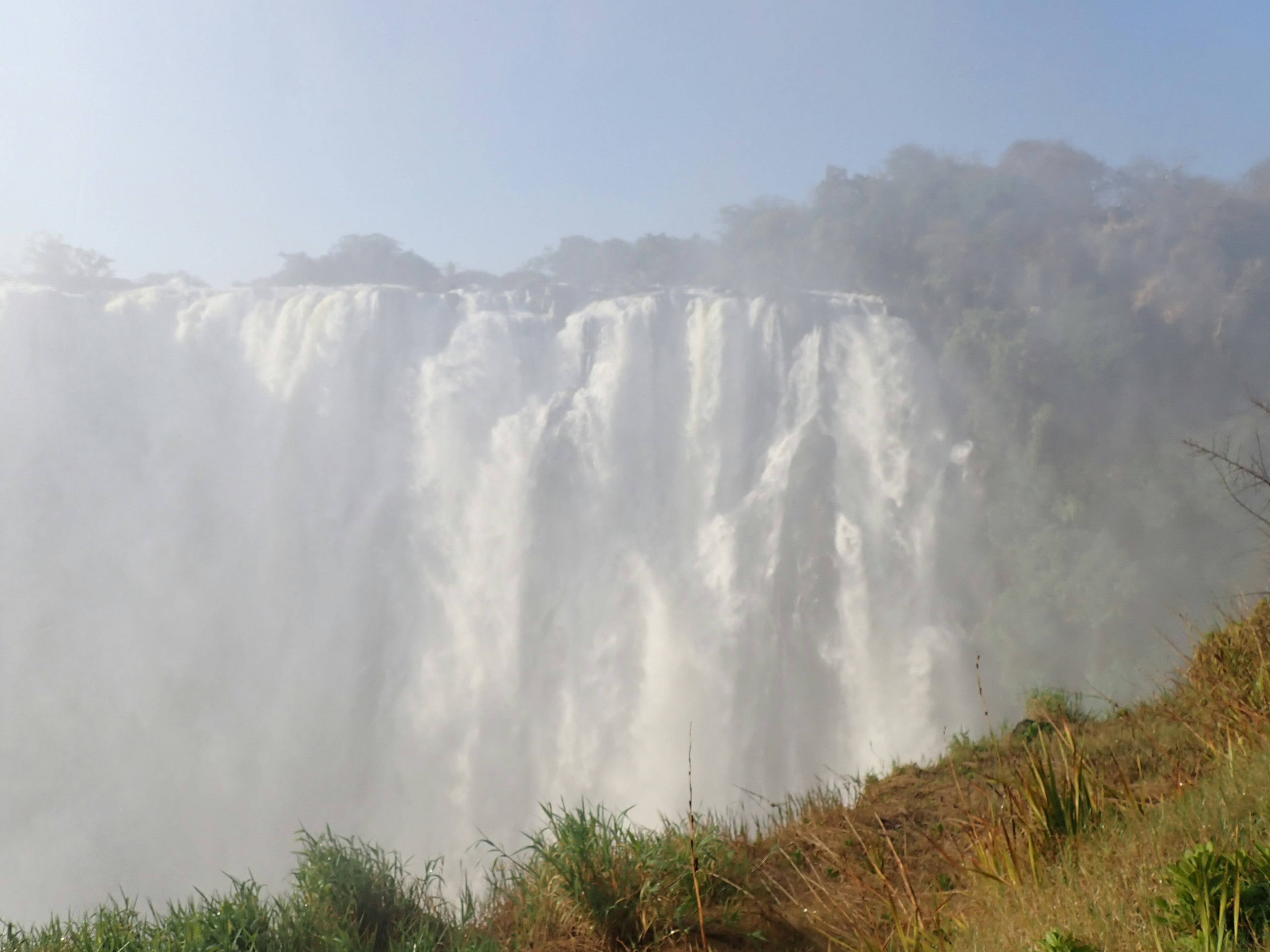 Majestätischer Wasserfall mit aufsteigendem Nebel von fließendem Wasser und umliegendem Grün