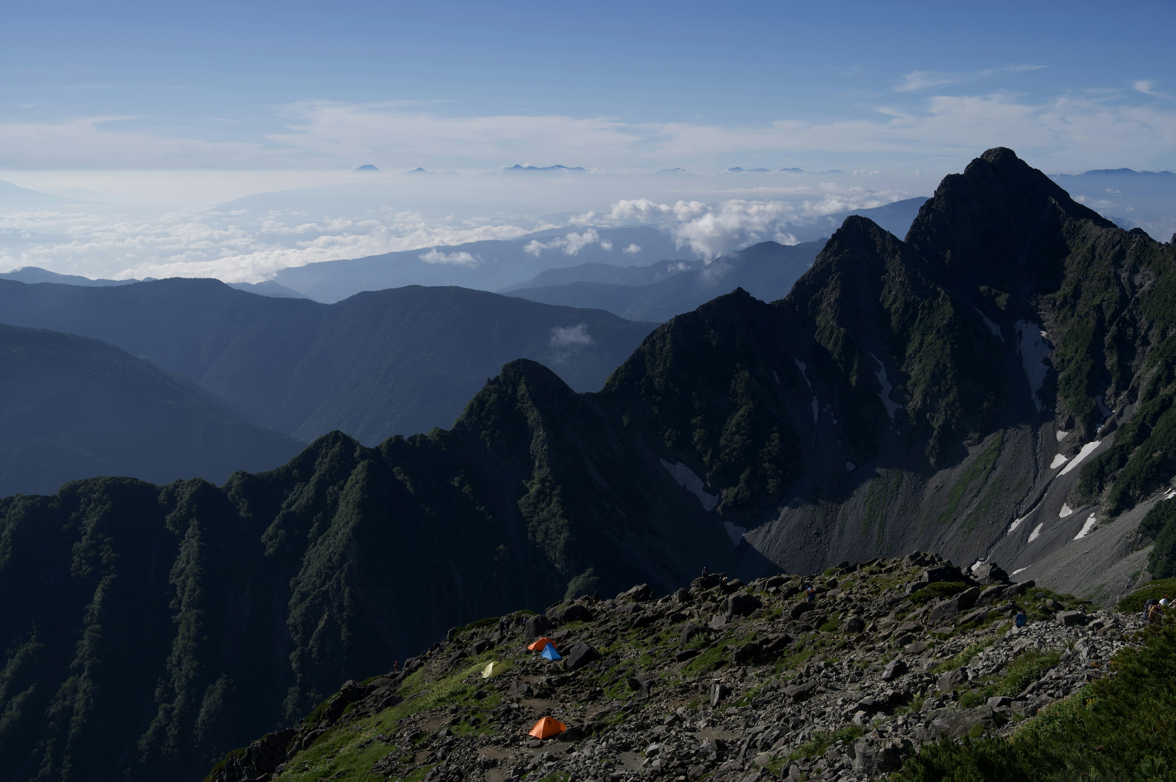 Berglandschaft mit bunten Zelten und klarem blauen Himmel