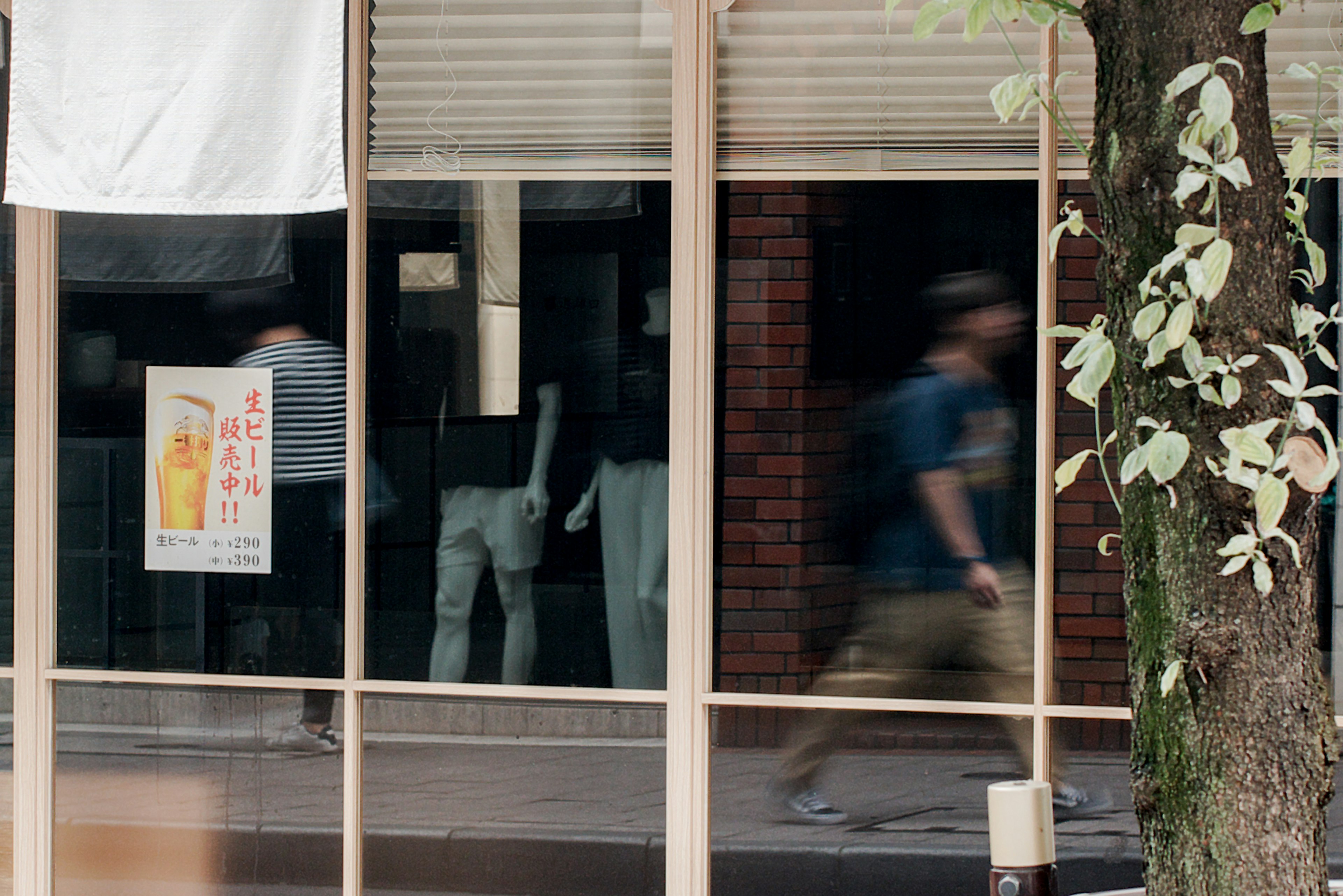 Reflection of people and mannequins in a store window