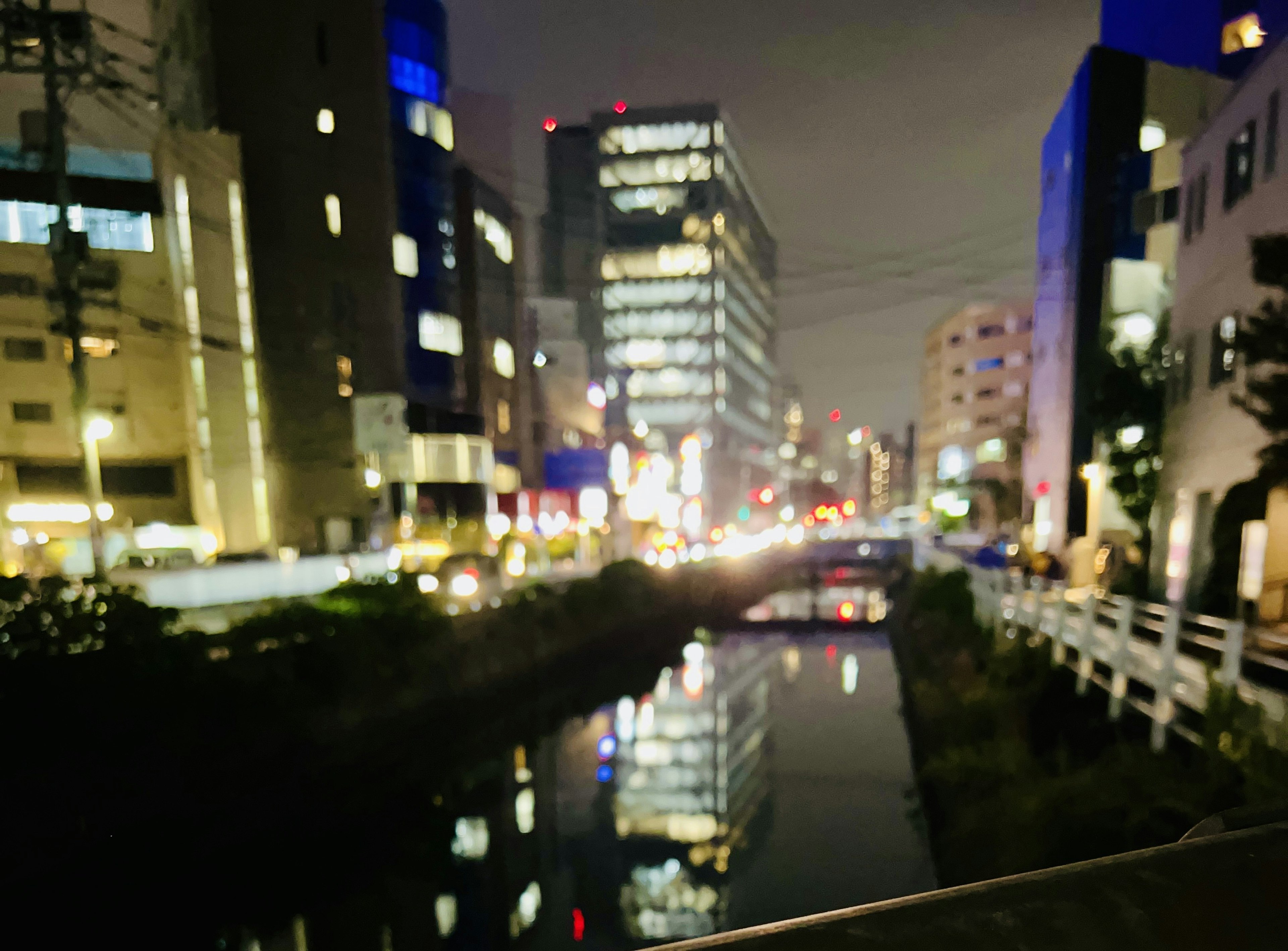 Nachtstadtansicht mit Reflexionen im Fluss und beleuchteten Gebäuden