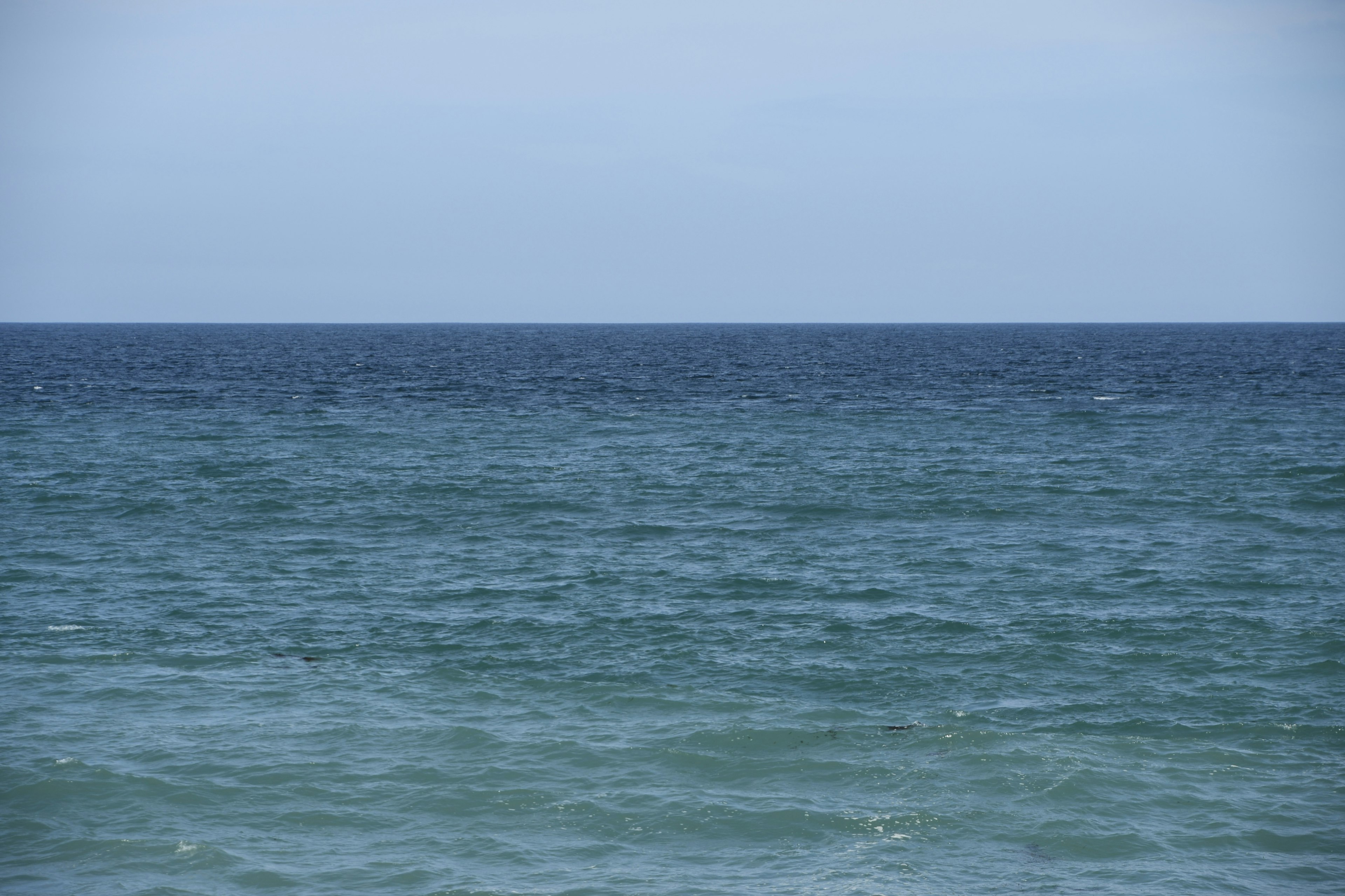 Eine Landschaft, die die Grenze zwischen blauem Meer und Himmel zeigt