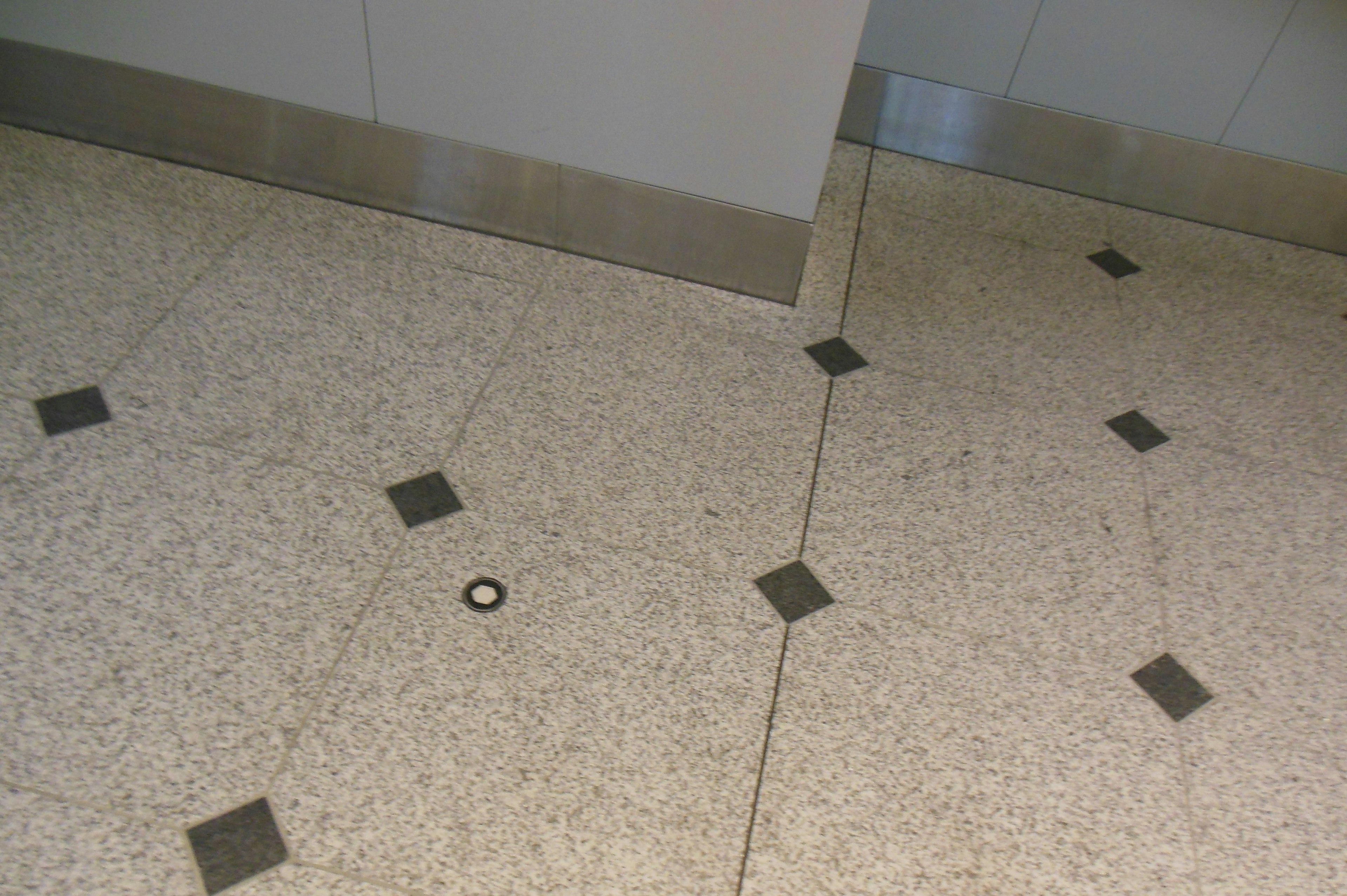 Image of floor tiles with a small ring on the ground